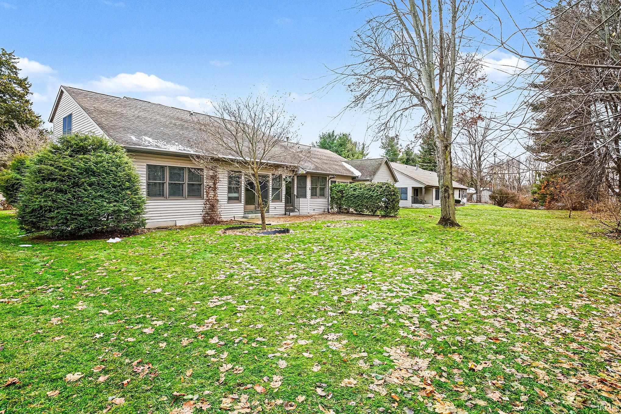 Back of property featuring a yard and roof with shingles