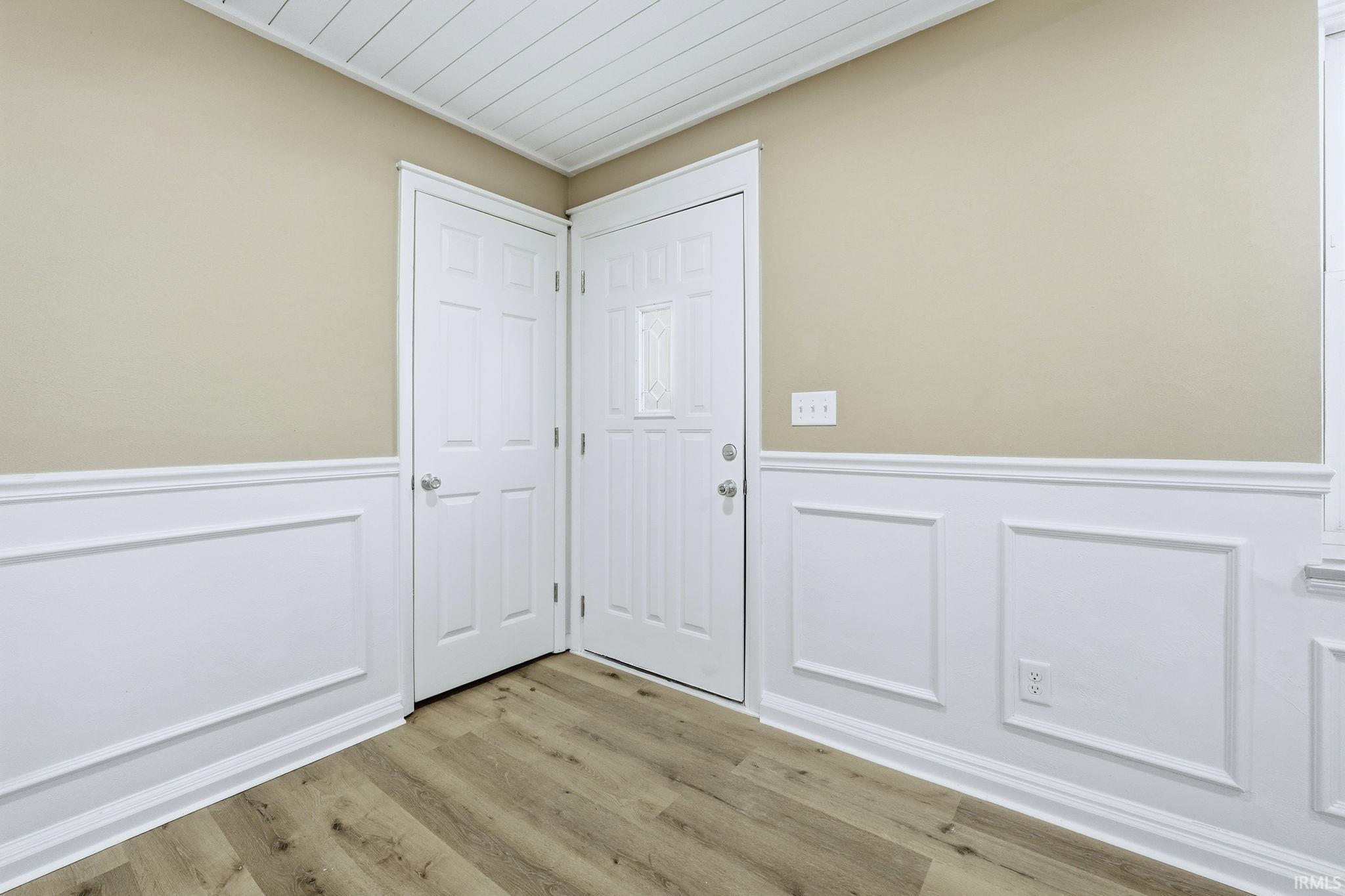 Entryway with wainscoting, a decorative wall, wood finished floors, and wood ceiling