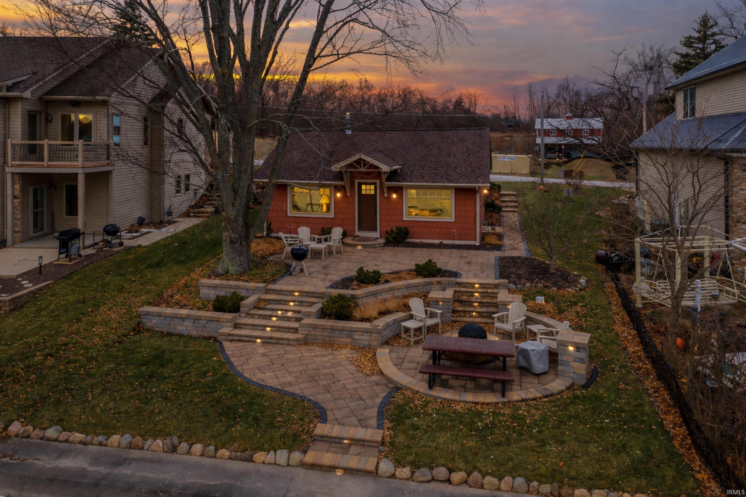 View of front of home with a patio area, a fire pit, and a yard