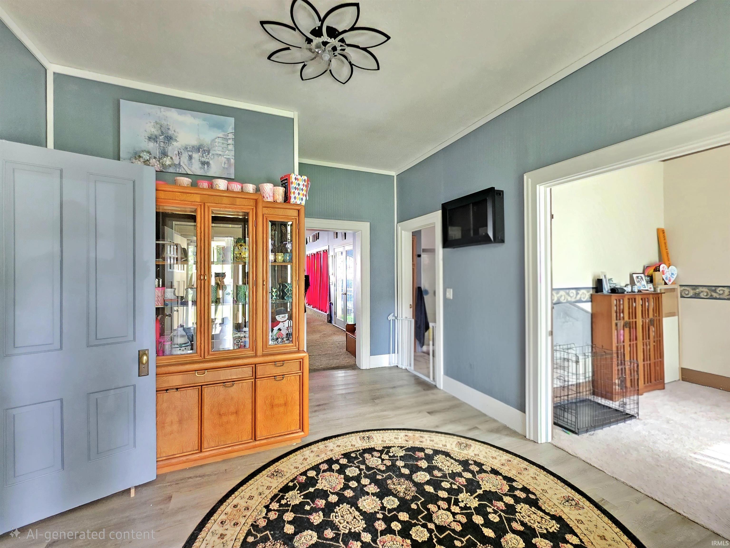 Foyer featuring wood-finish flooring, light blue wall paint with white trim, and a decorative ceiling fixture