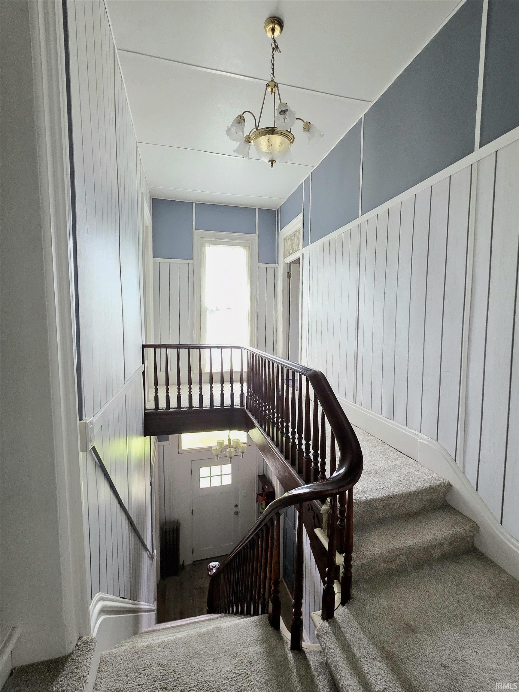 Multi-level staircase featuring dark wood banisters and carpeted treads