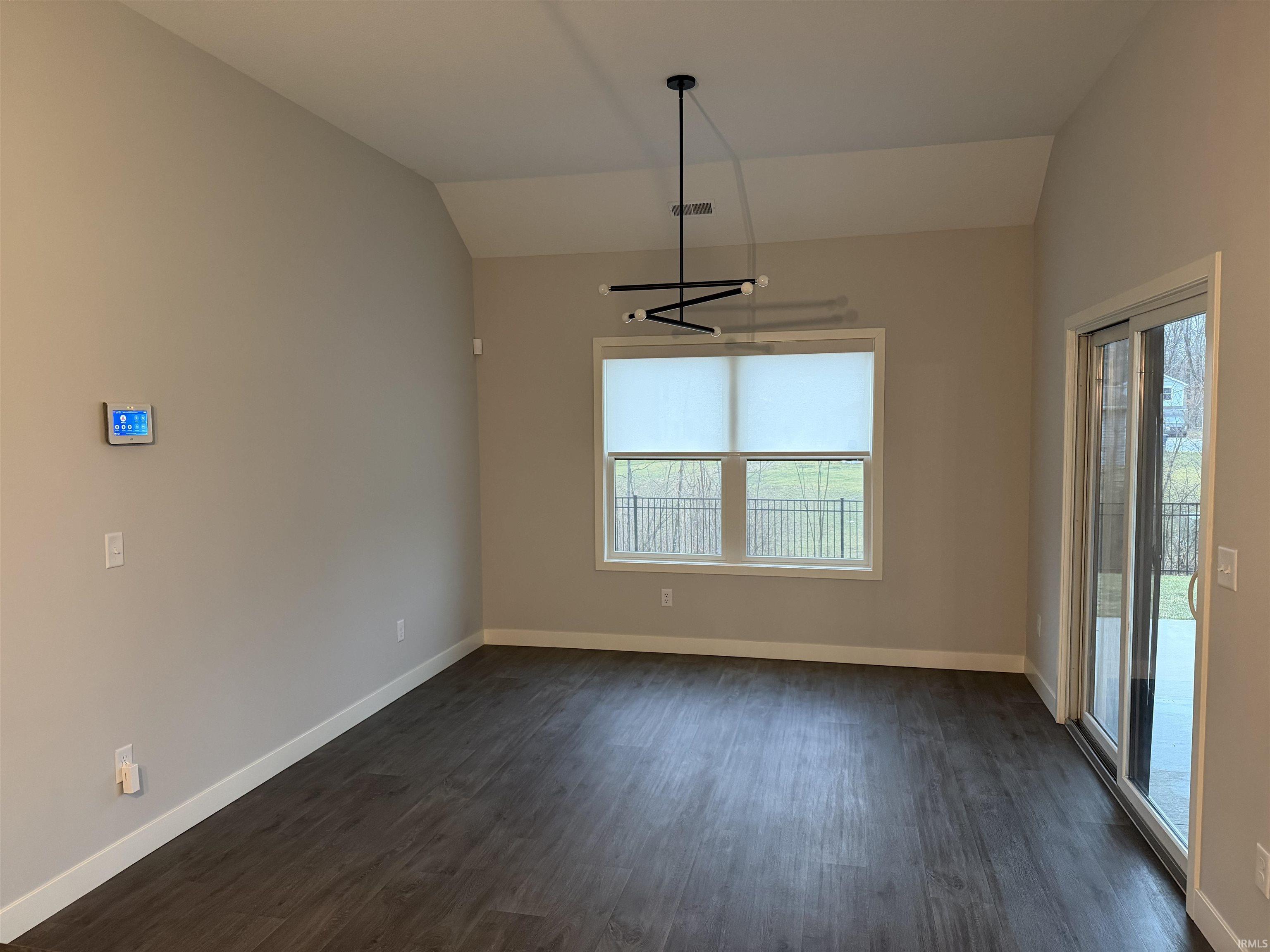 Breakfast Nook featuring lofted ceiling, dark wood finished floors, and a chandelier