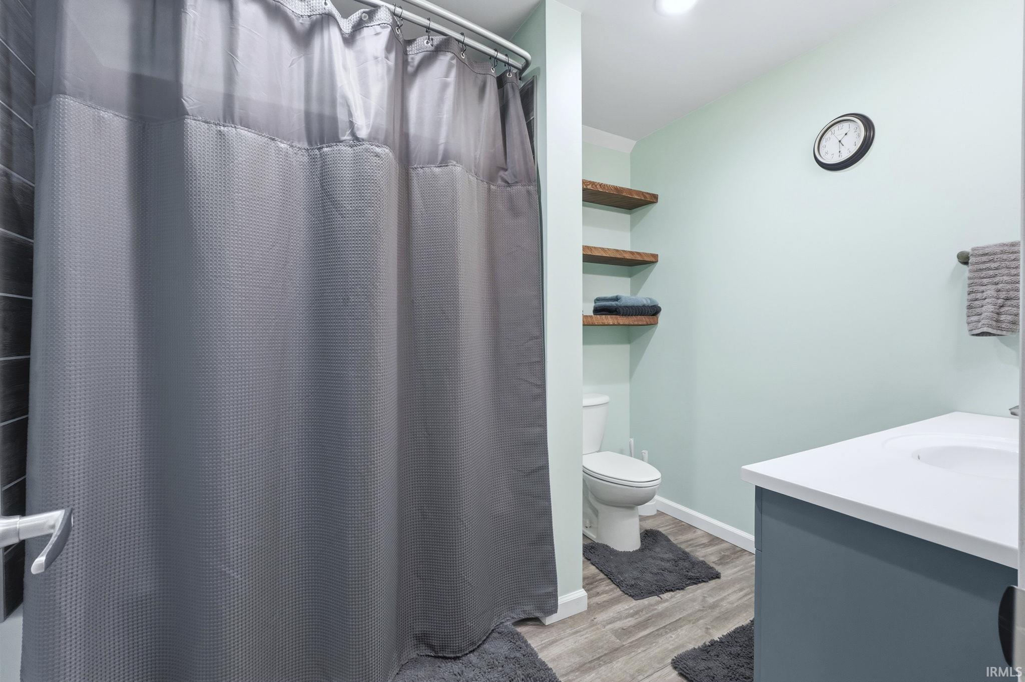 Bathroom featuring vanity, a shower with curtain, and light wood finished floors