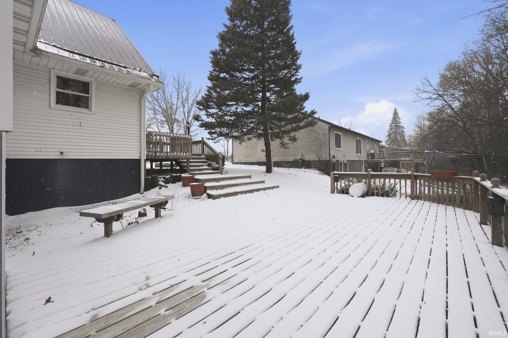Snow covered deck featuring stairs