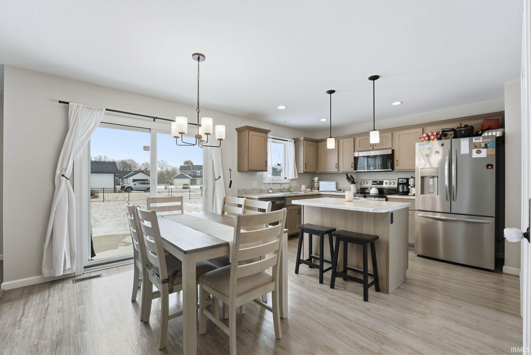 Dining space with a chandelier, light wood-style flooring, and recessed lighting