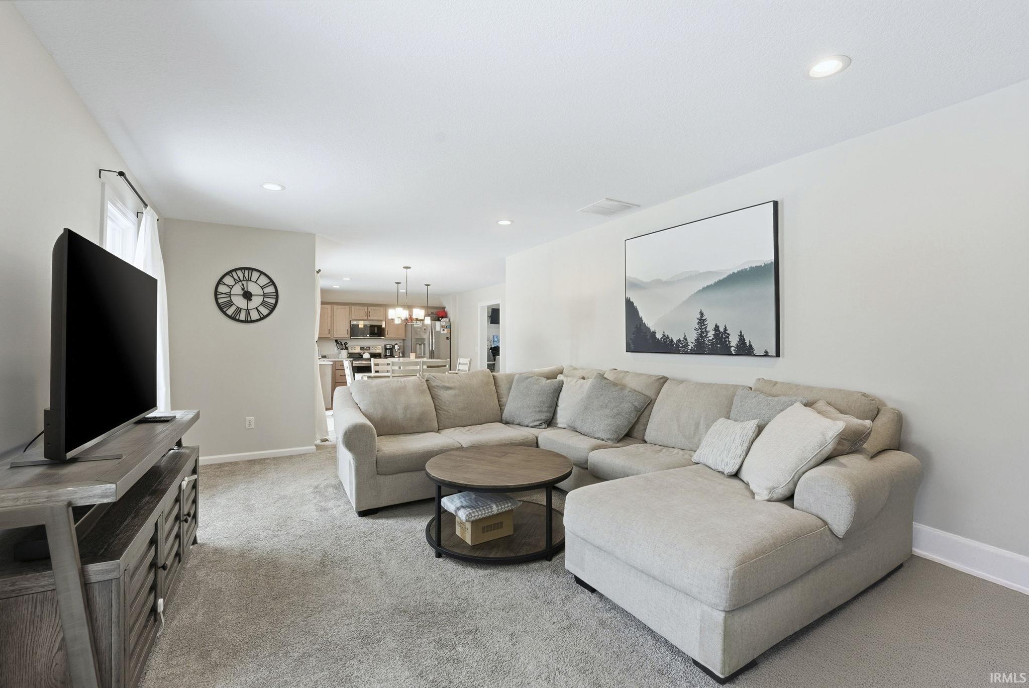 Living area featuring light carpet and recessed lighting