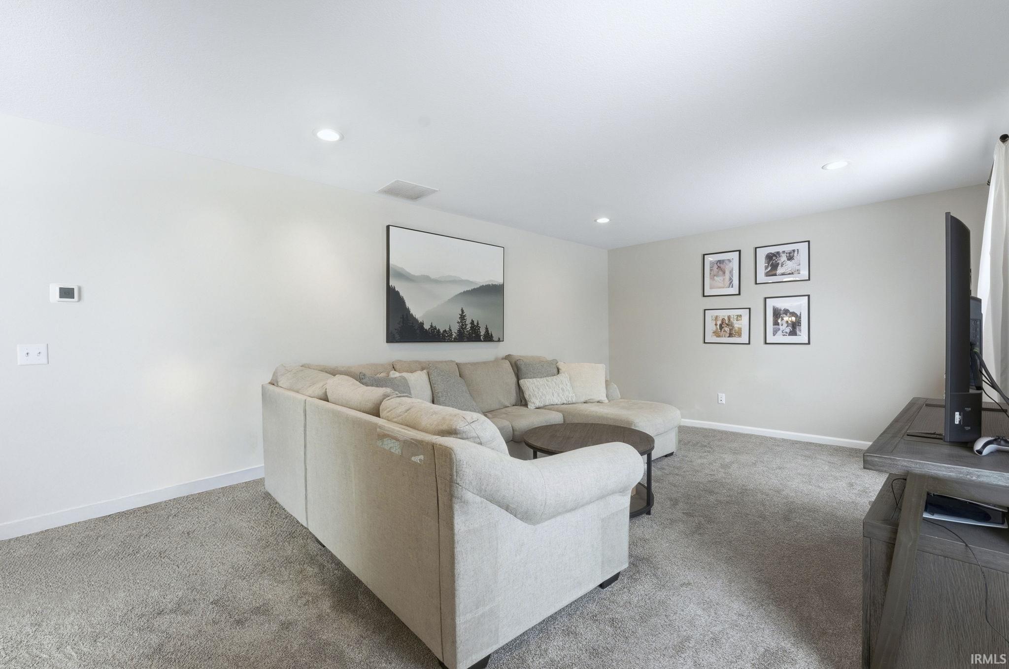 Living area featuring light carpet and recessed lighting