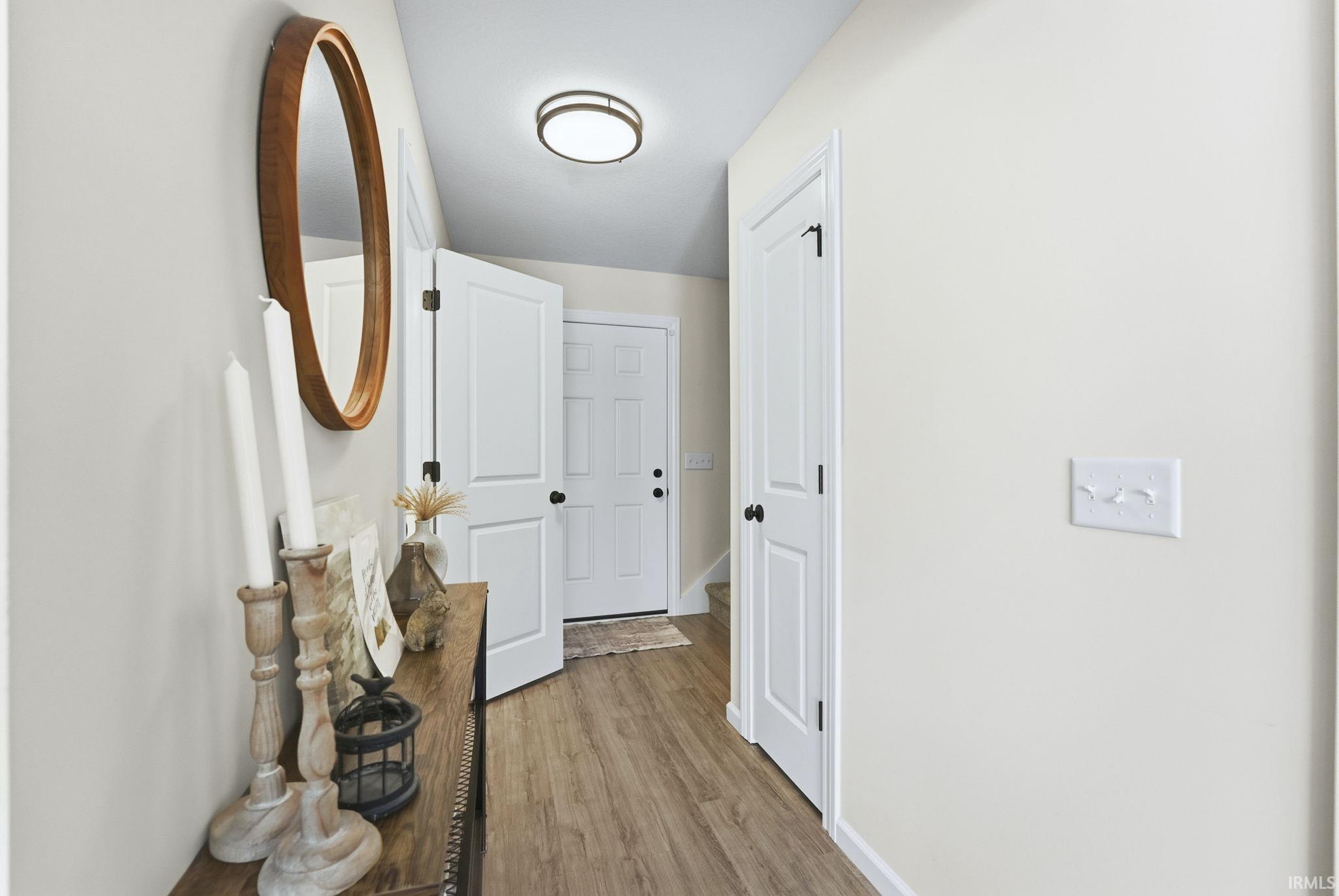 Hallway with baseboards and light wood-style floors