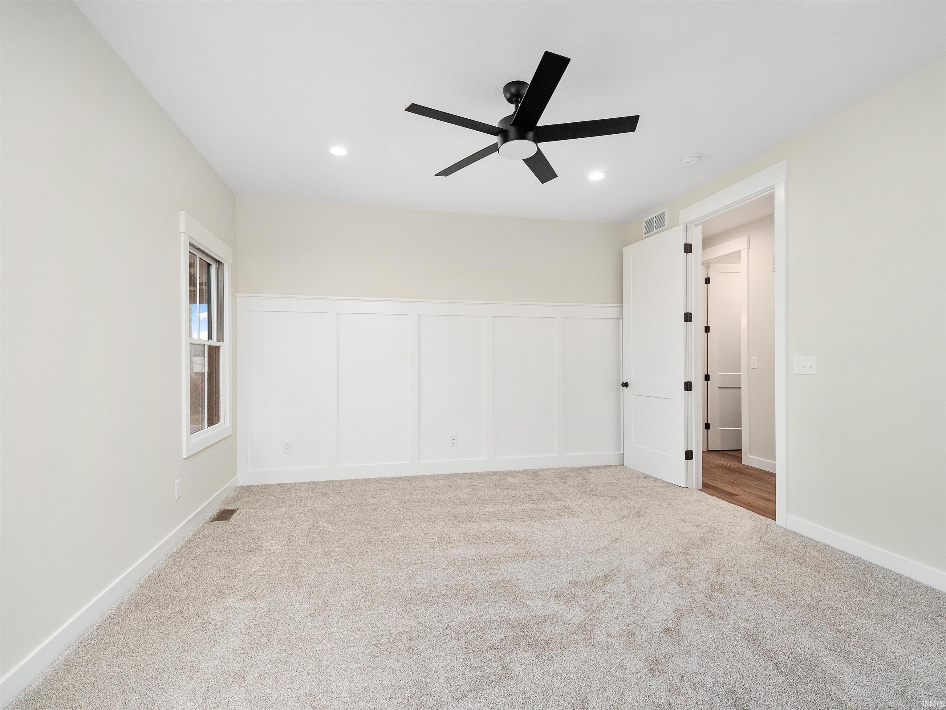 Featuring custom decorative wainscoting, ceiling fan, 8' interior doors, recessed lighting, lots of natural light