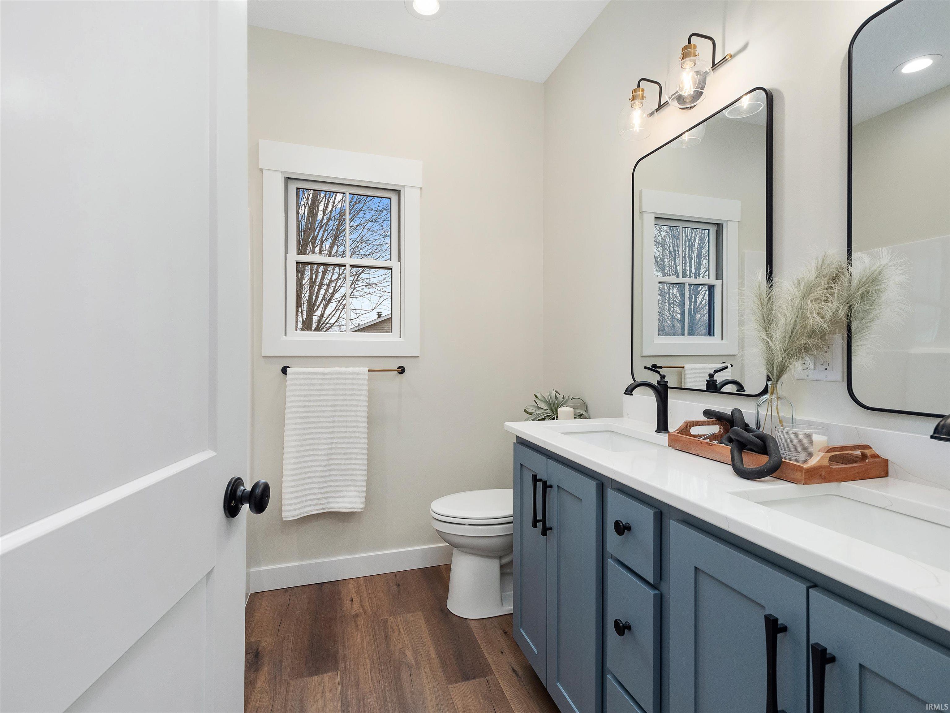 Beautiful custom double vanity, quartz counters, LVP floors, and recessed lighting