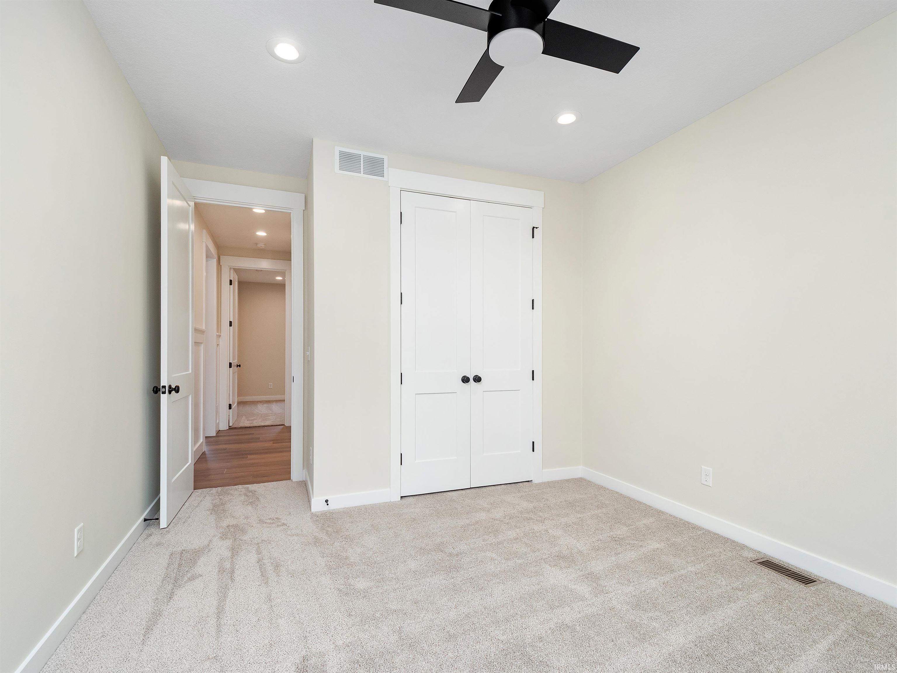 Neutral carpet, custom closet system, 8' interior wood paneled doors, recessed lighting, and ceiling fan