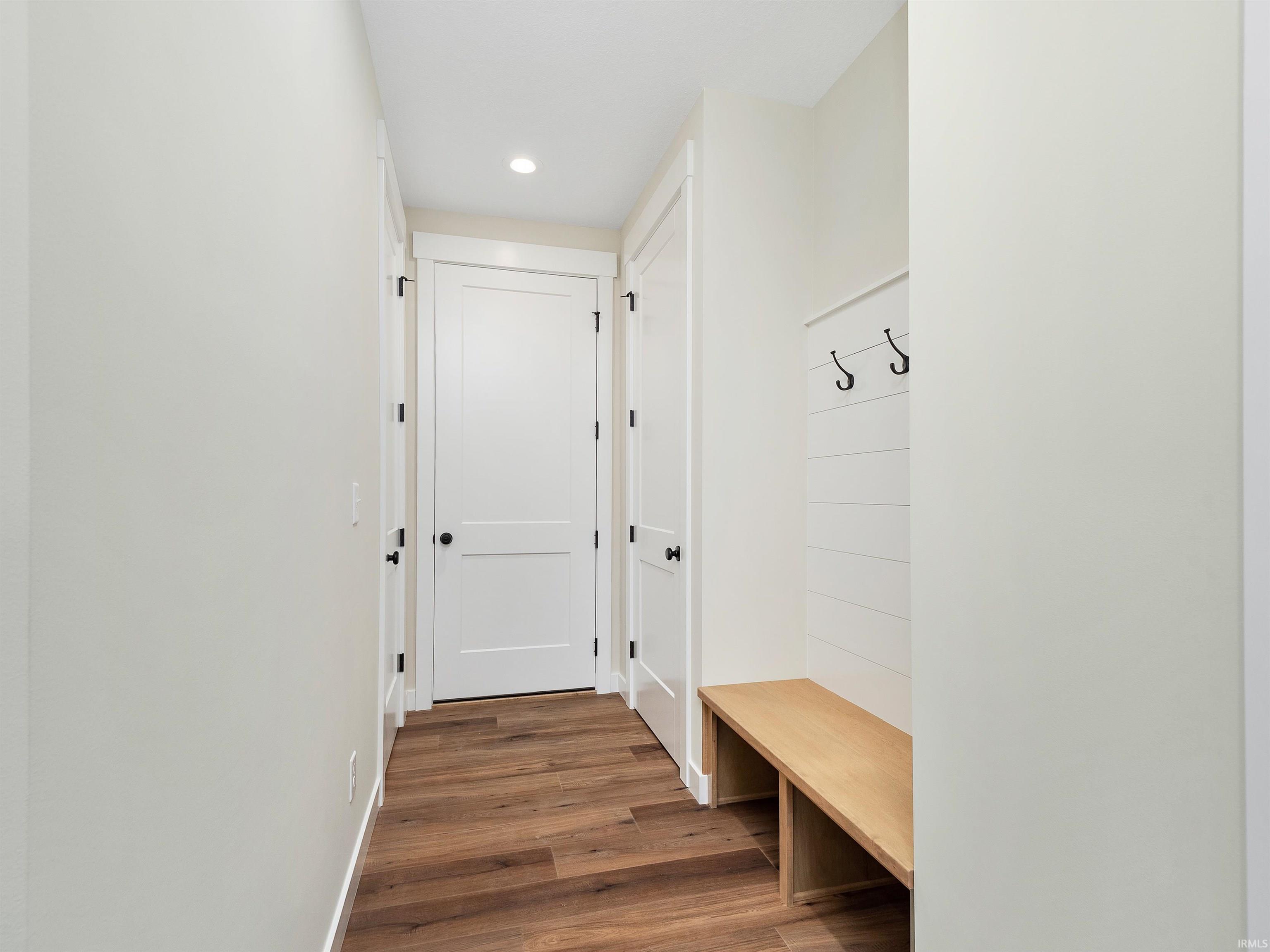 Mudroom w/LVP flooring and recessed lighting, custom built in storage with hooks