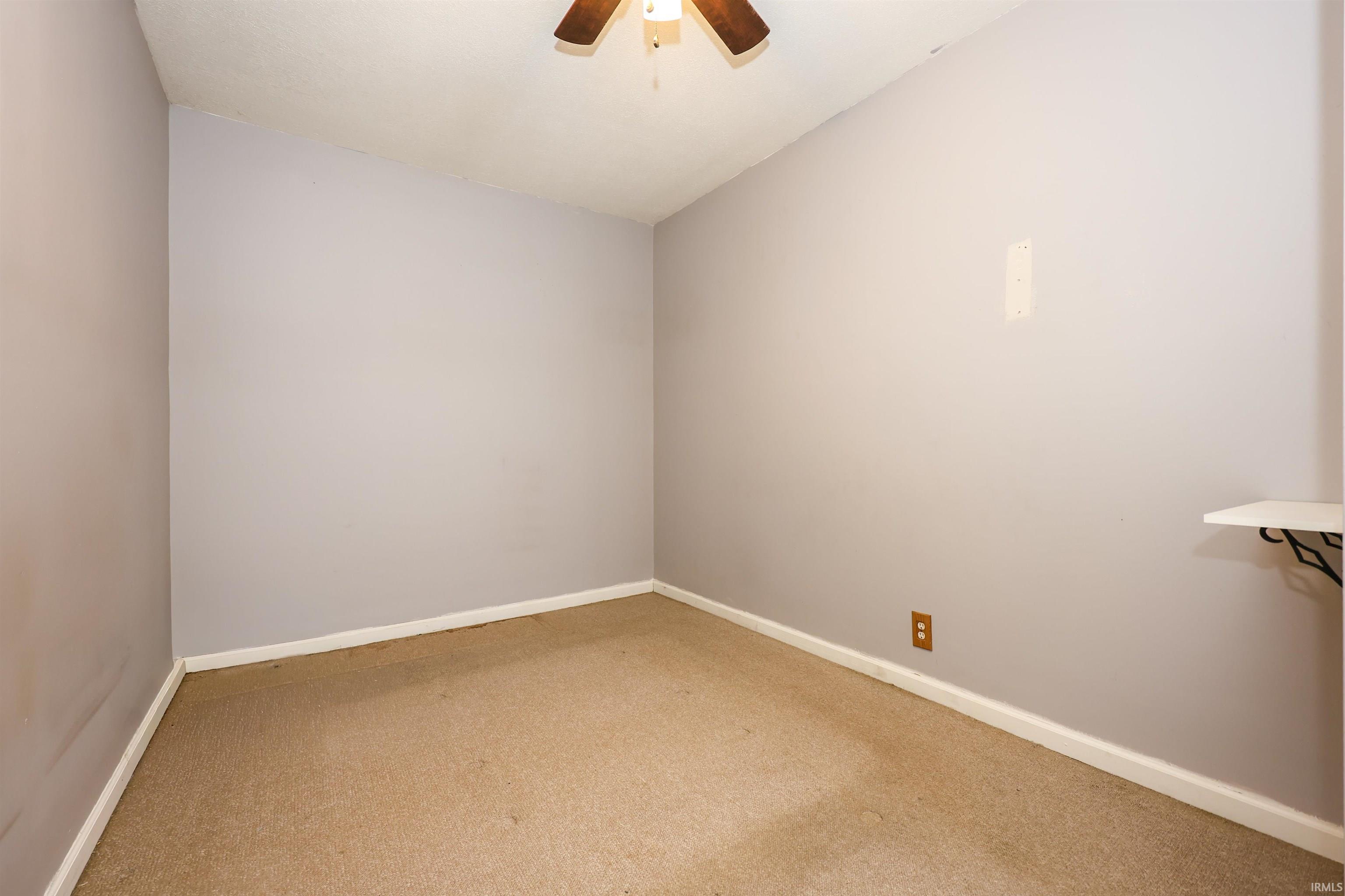 Spare room featuring a ceiling fan and carpet floors