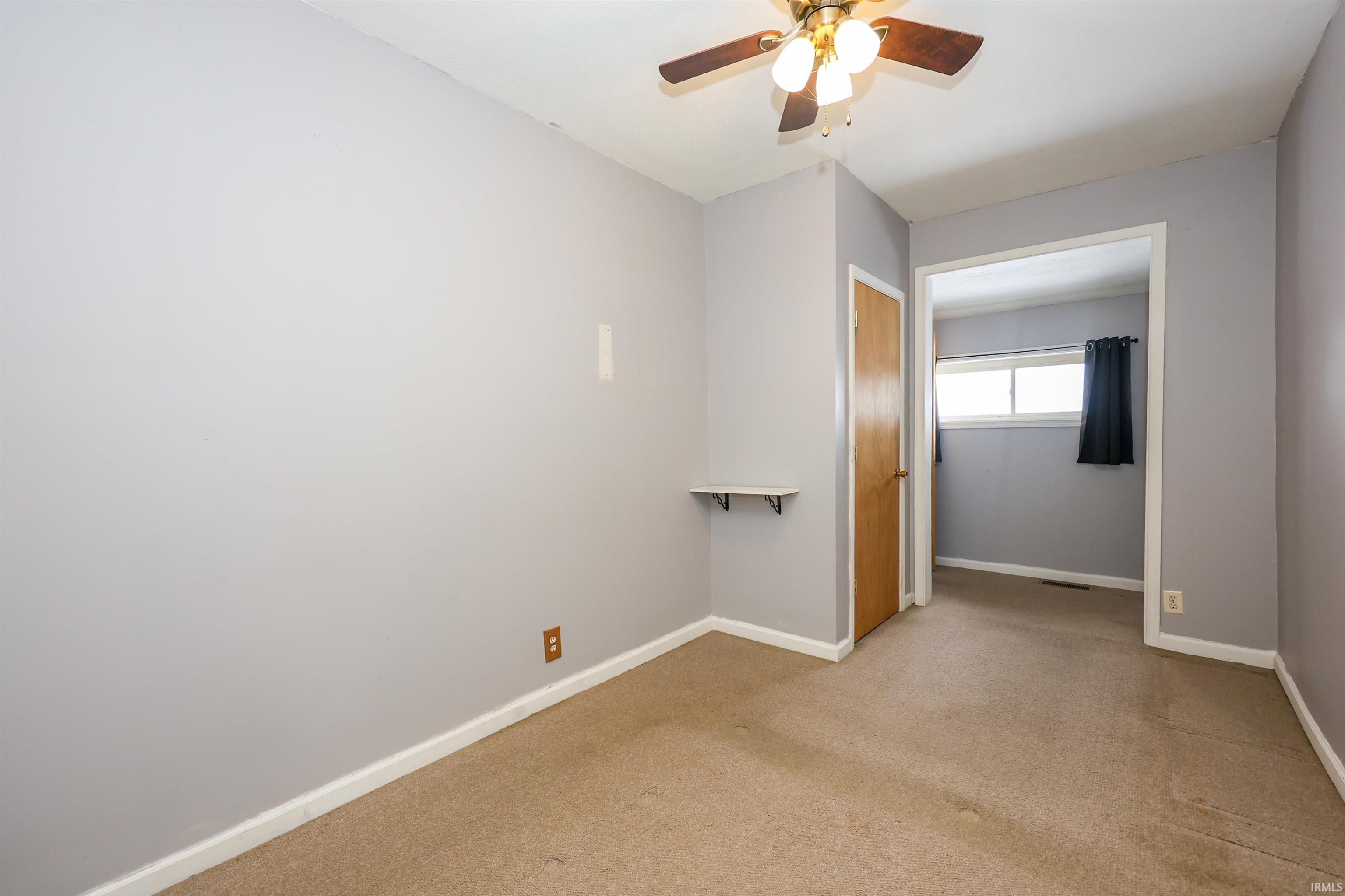 Spare room with light colored carpet and ceiling fan