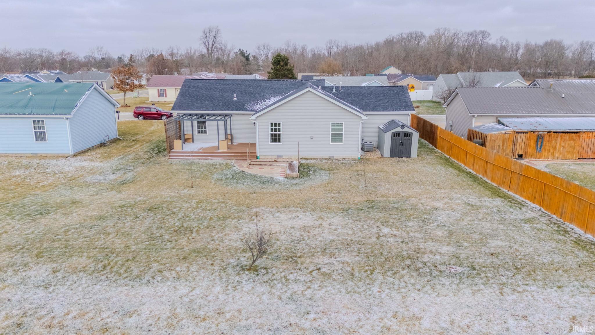 Rear view of house with a storage shed, a fenced backyard, and a residential view
