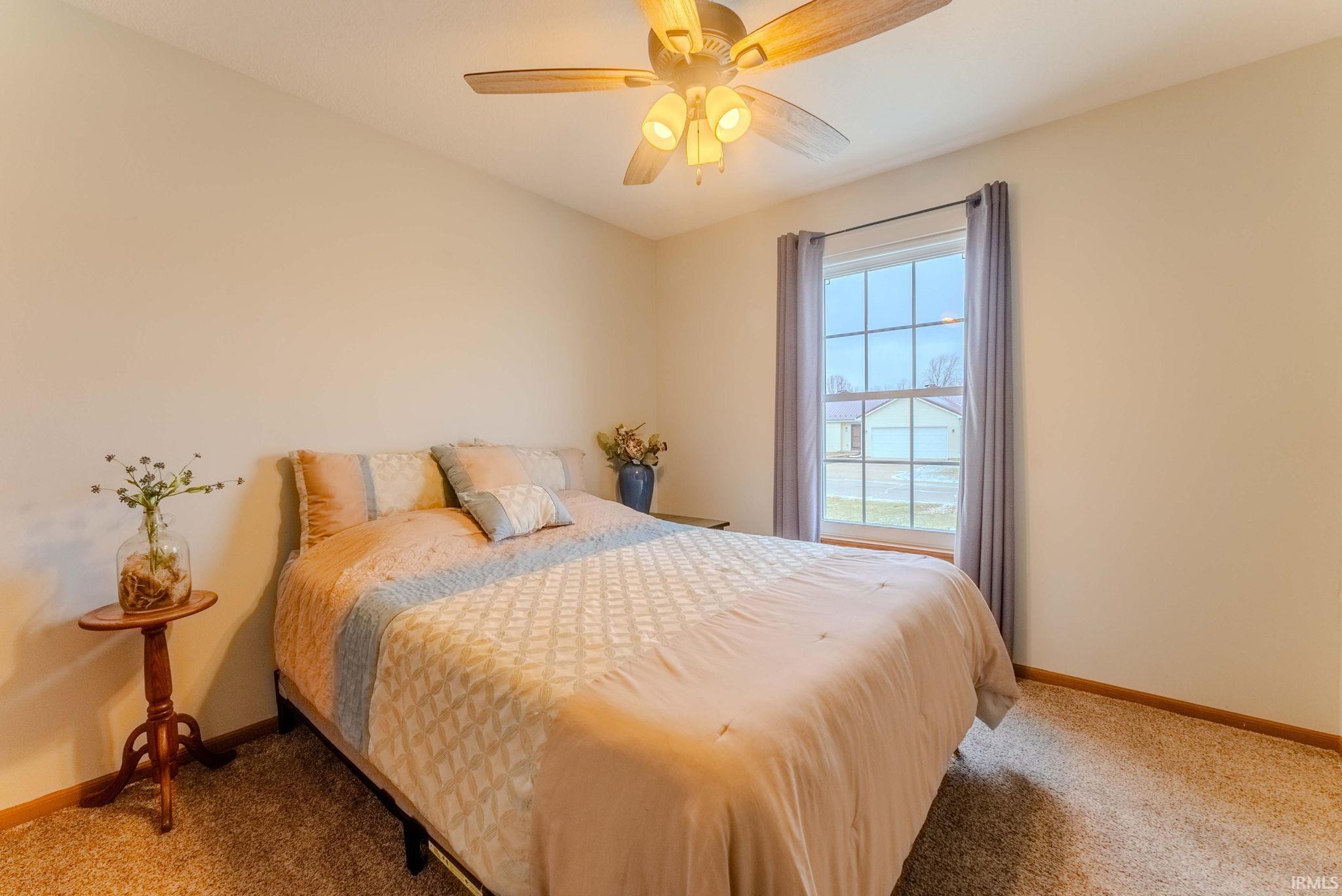 Bedroom with a ceiling fan and carpet floors
