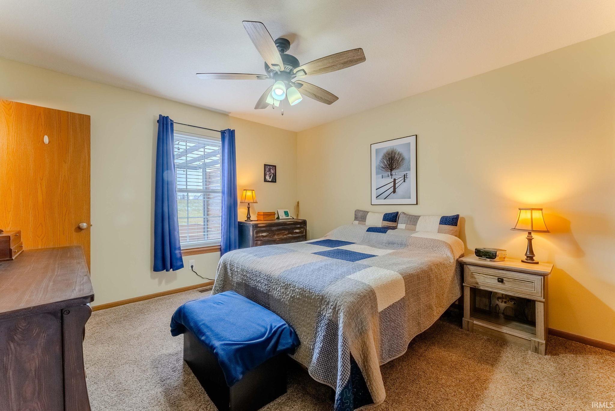 Bedroom with ceiling fan and carpet flooring