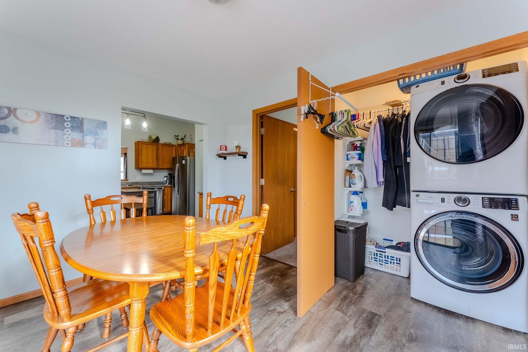 Laundry area featuring stacked washer / dryer and wood finished floors
