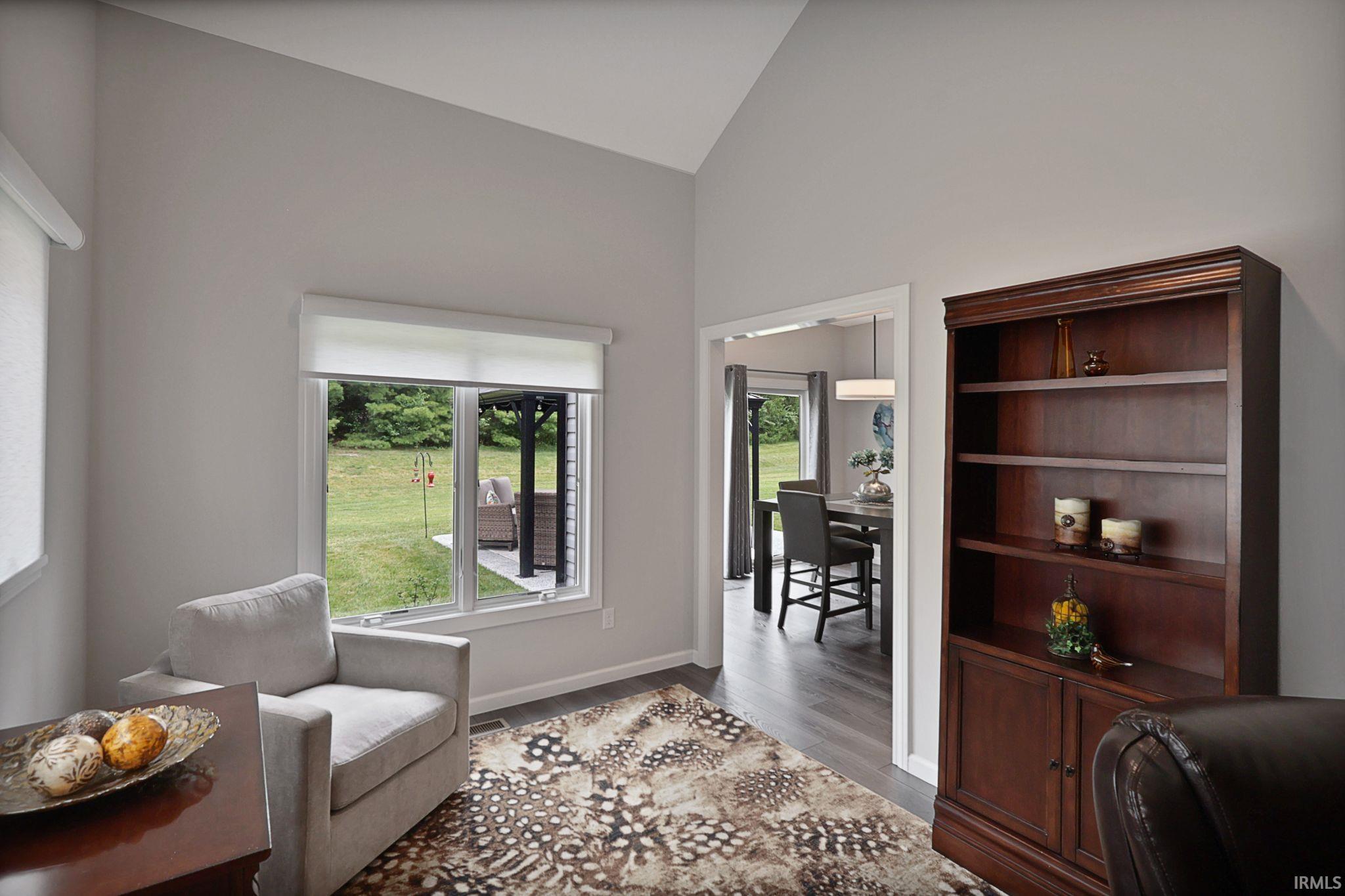 Office with wood finished floors and high vaulted ceiling