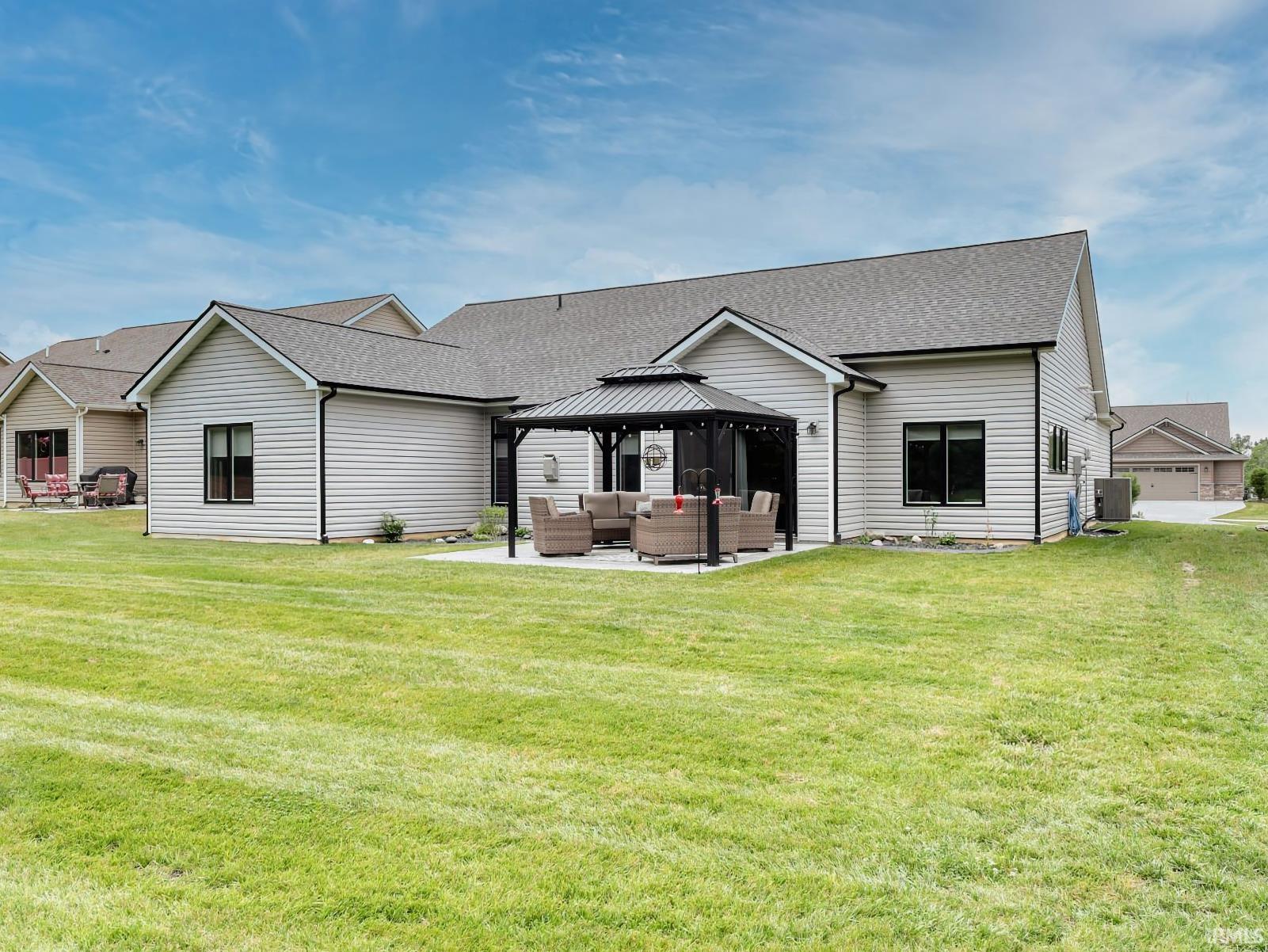 Back of house featuring a gazebo, a patio, outdoor lounge area, and roof with shingles