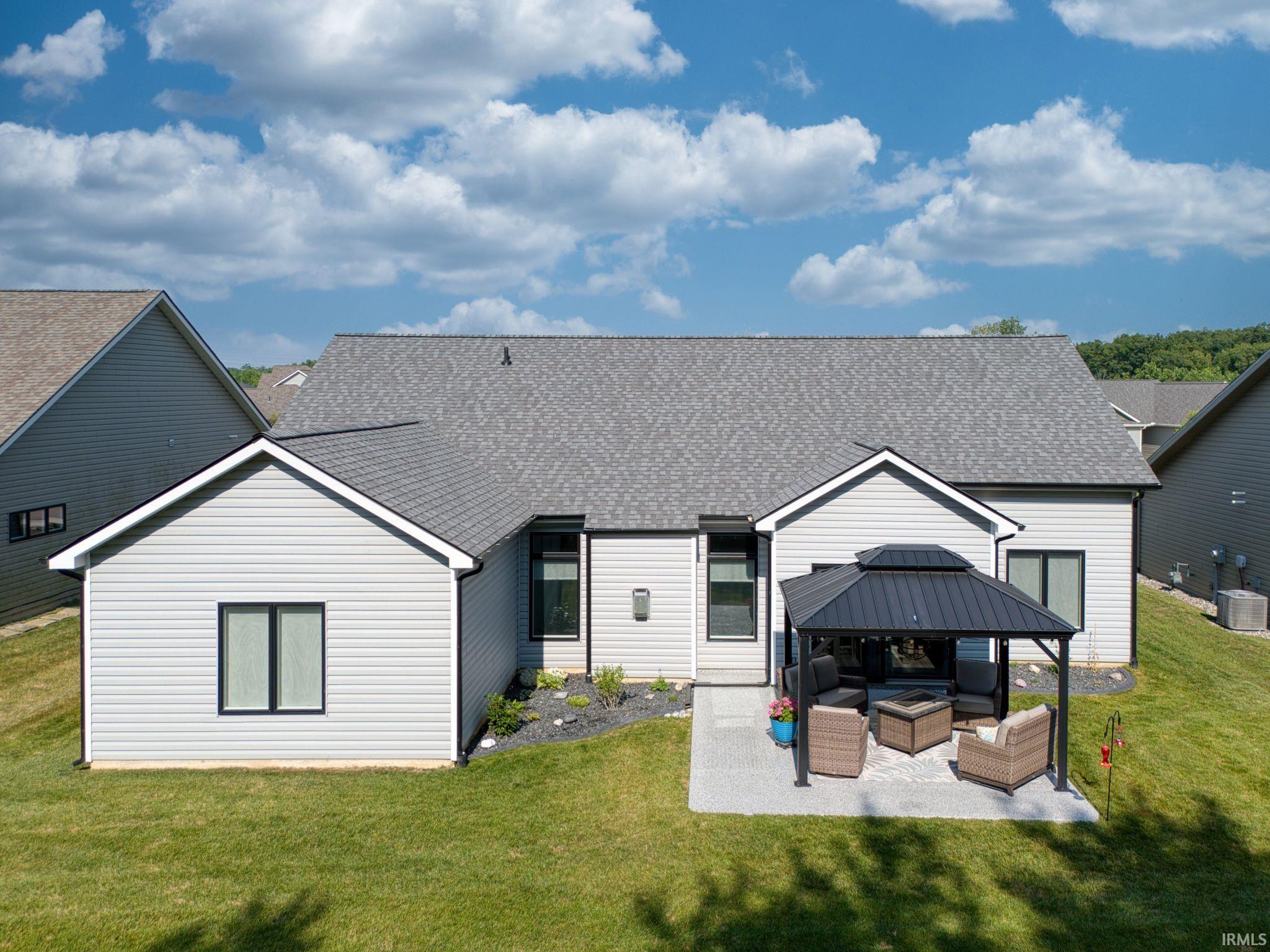 Rear view of house with outdoor lounge area, a shingled roof, and a yard