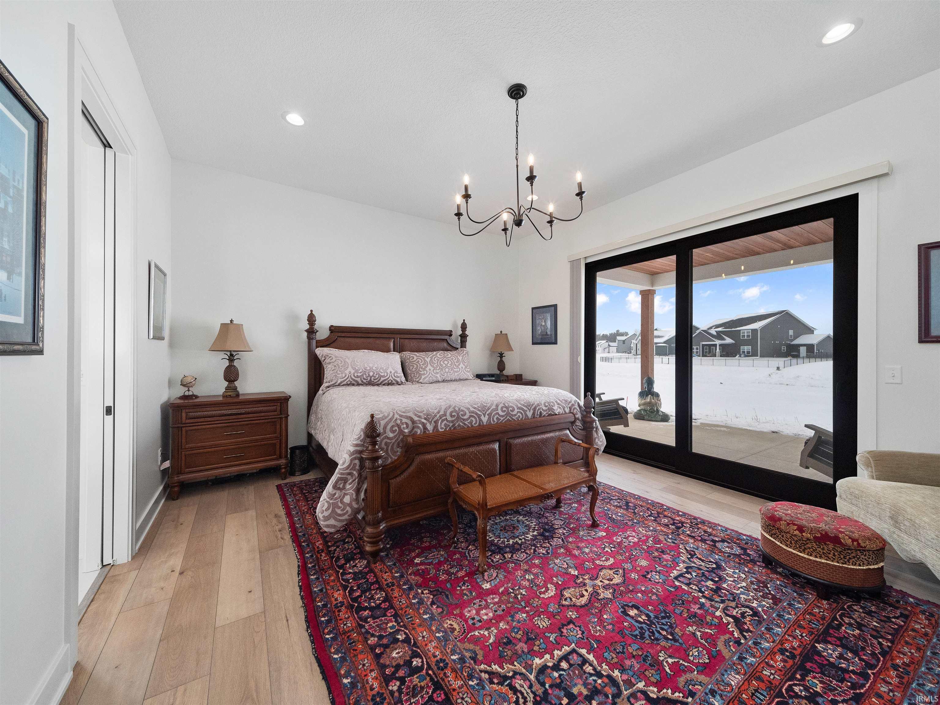 Bedroom featuring light wood finished floors, access to outside, a chandelier, and recessed lighting