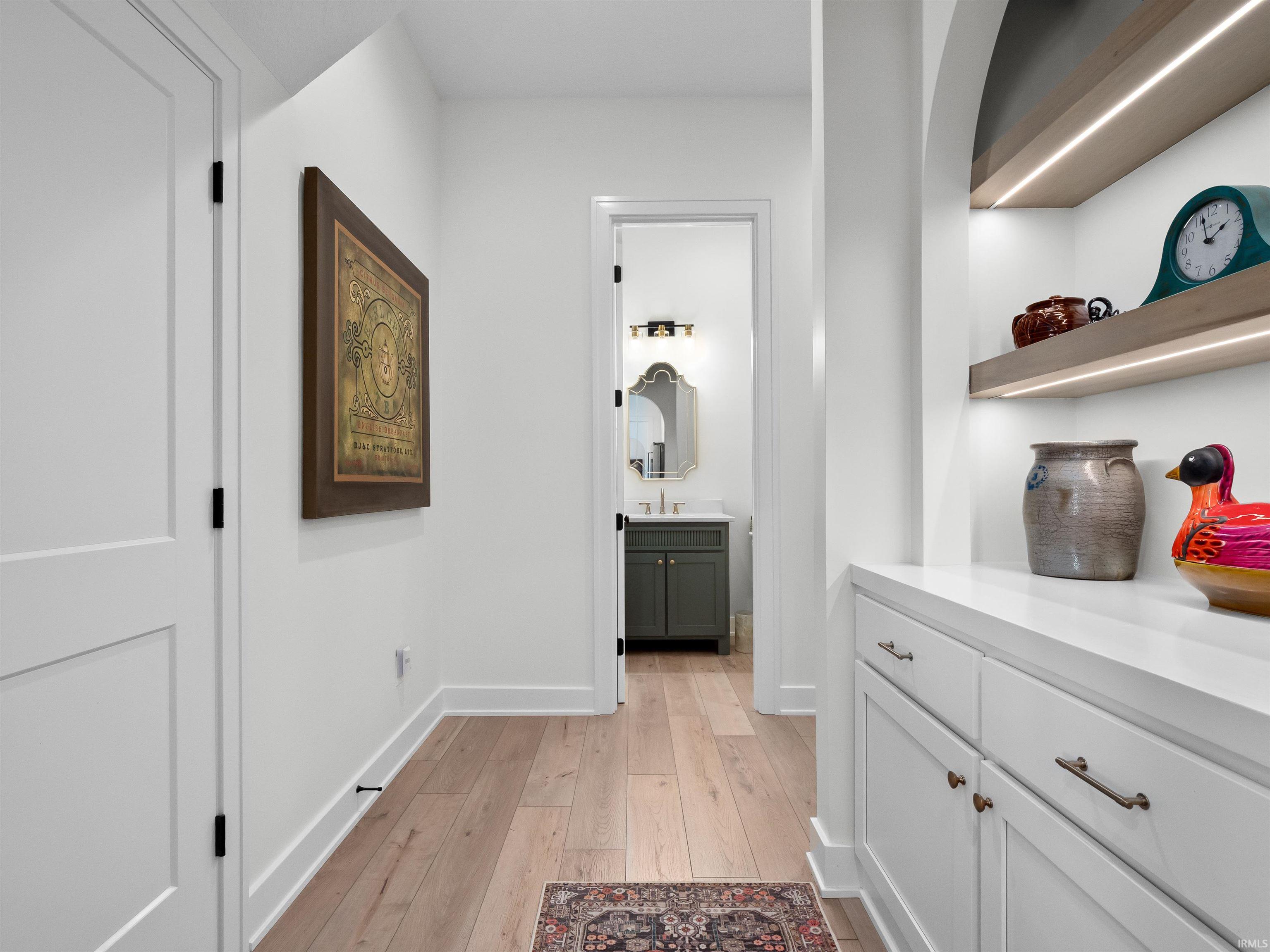 Corridor featuring light wood-style flooring and baseboards