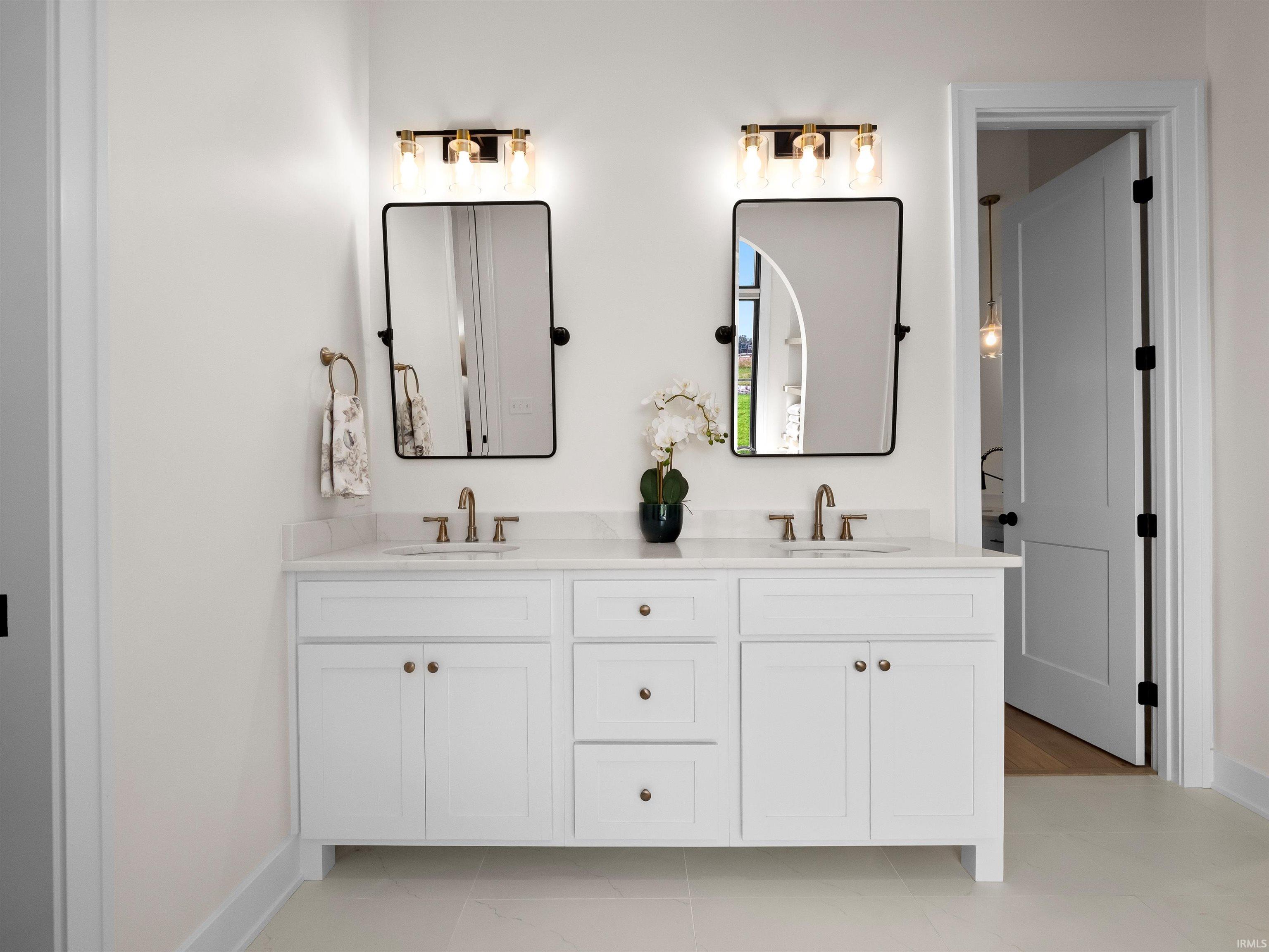 Bathroom featuring double vanity and baseboards