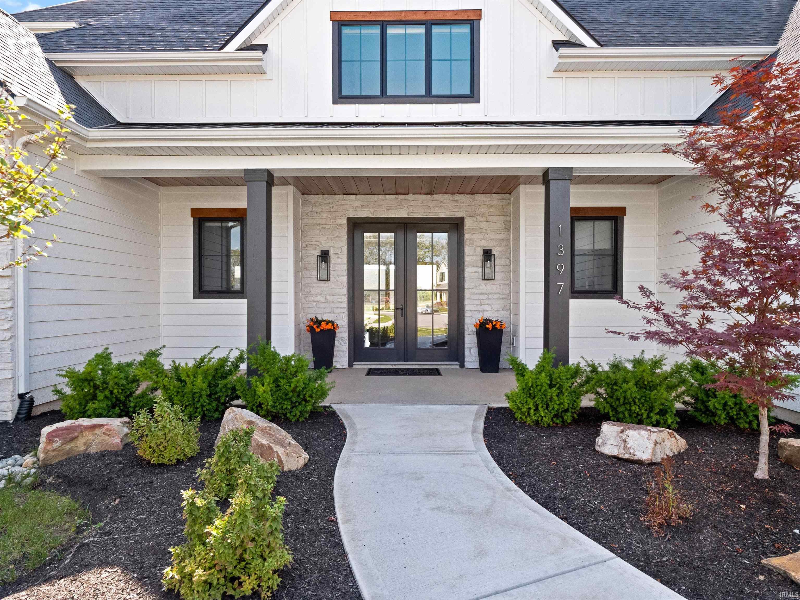 Doorway to property with board and batten siding, a porch, a shingled roof, and french doors