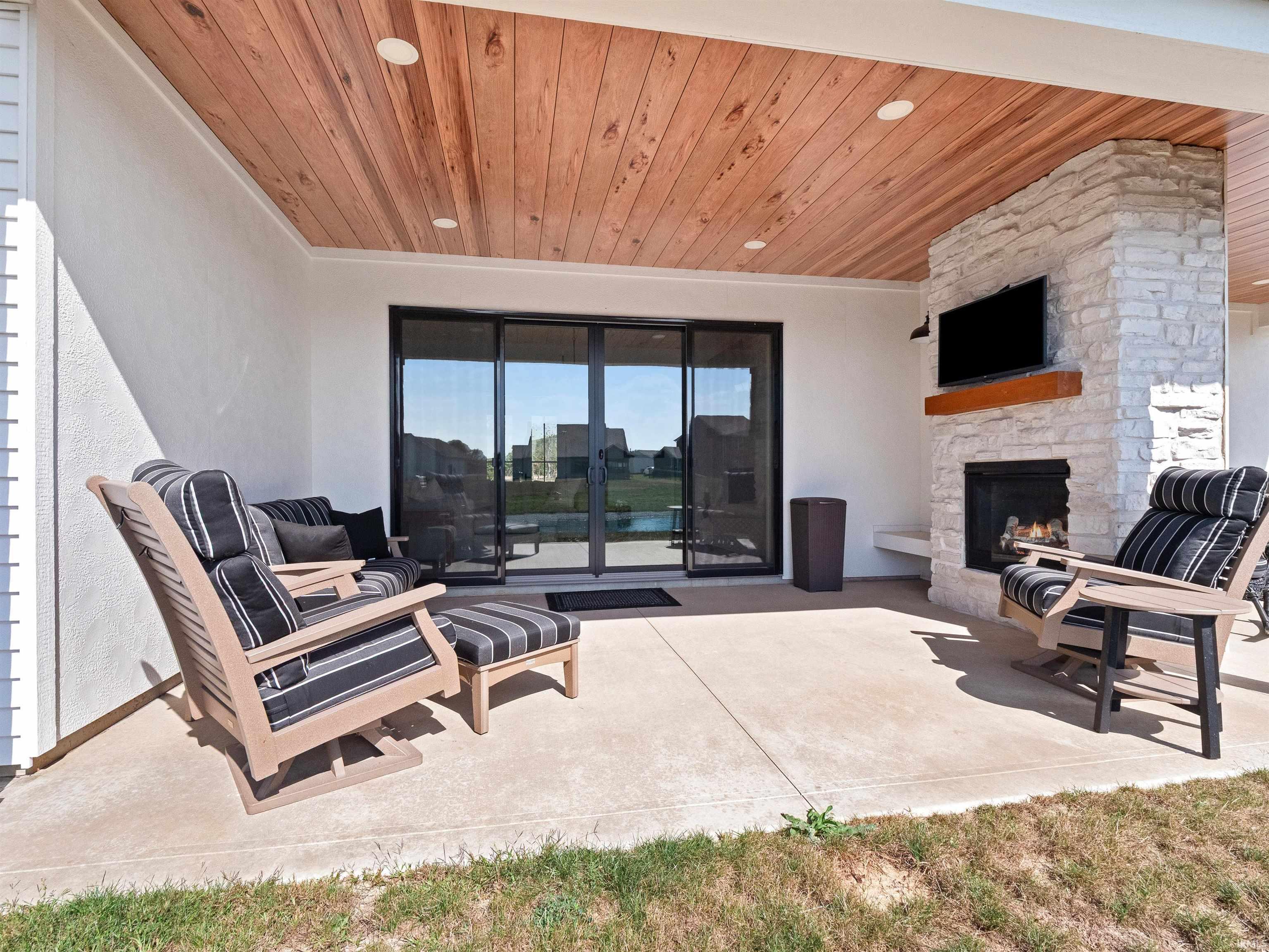 View of patio featuring an outdoor stone fireplace