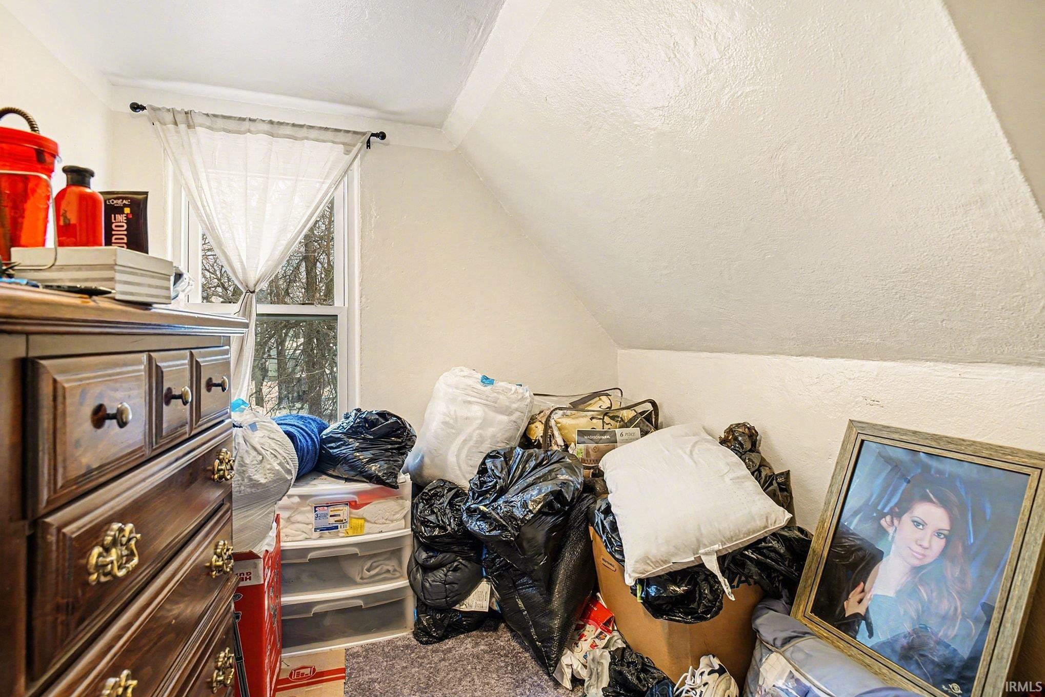 Bedroom with vaulted ceiling and a textured ceiling
