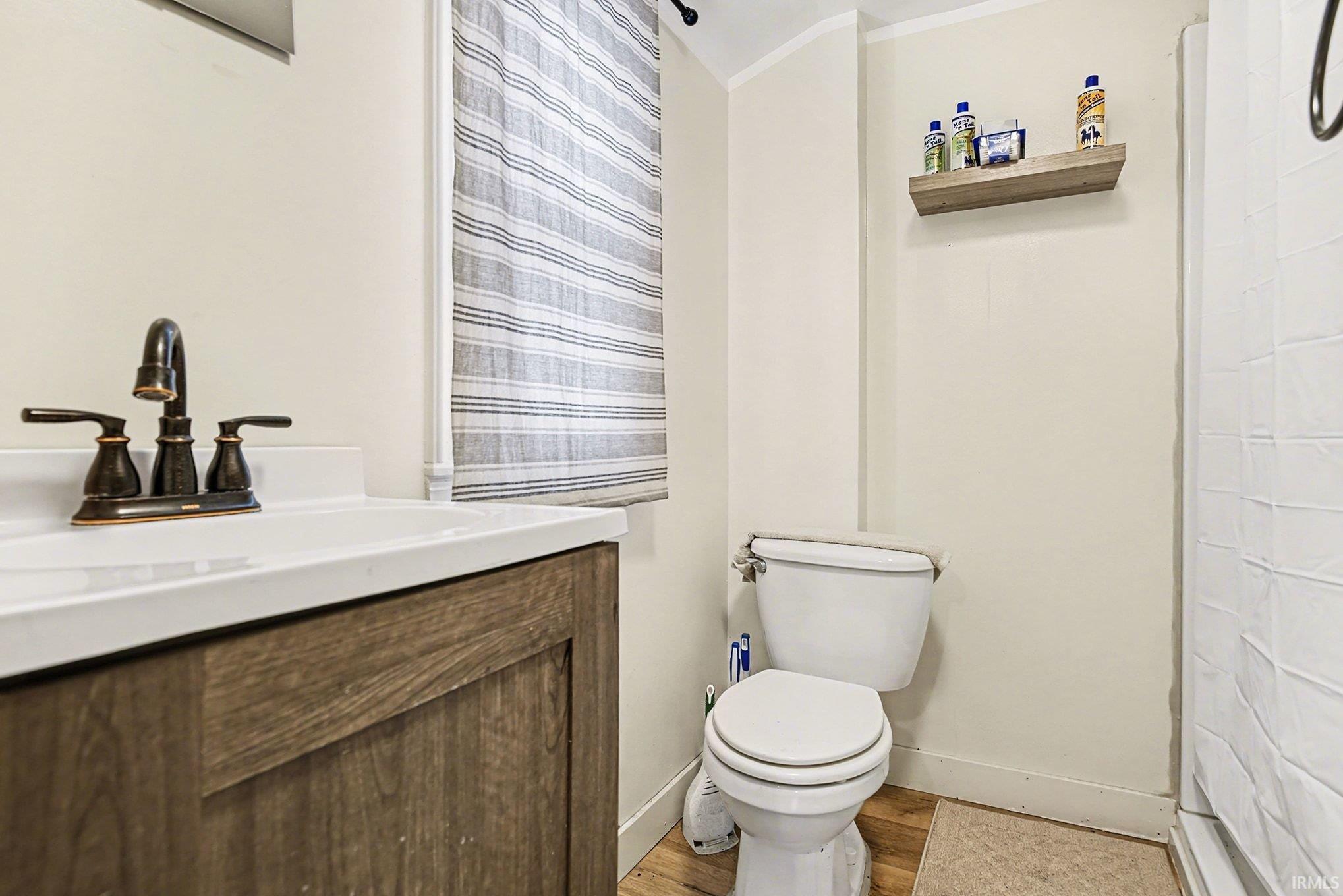 Bathroom featuring vanity, radiator, and light wood-type flooring