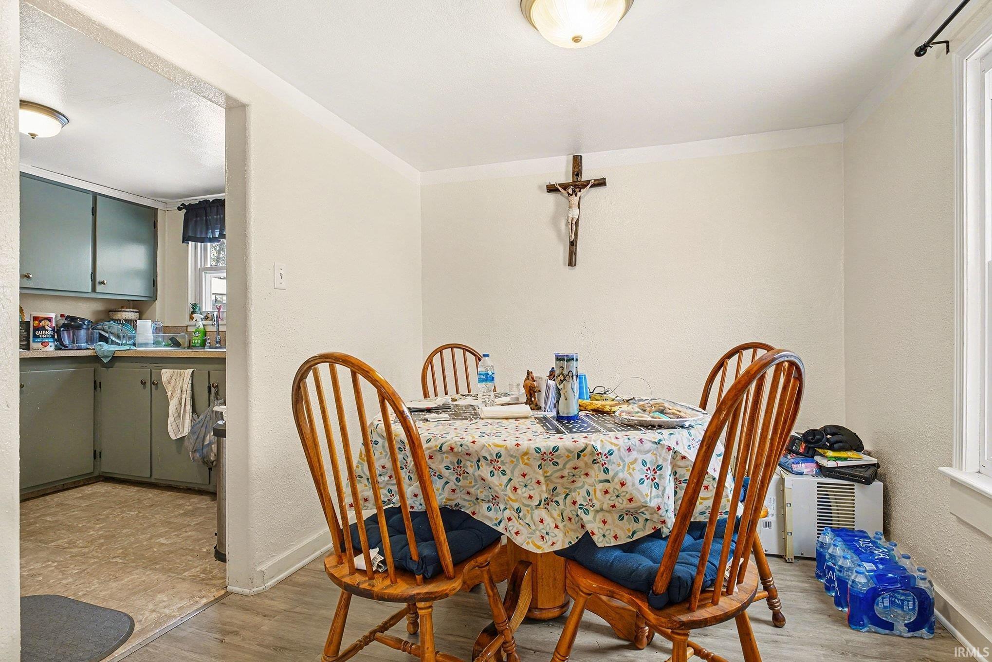 Dining room with light wood finished floors and a textured wall