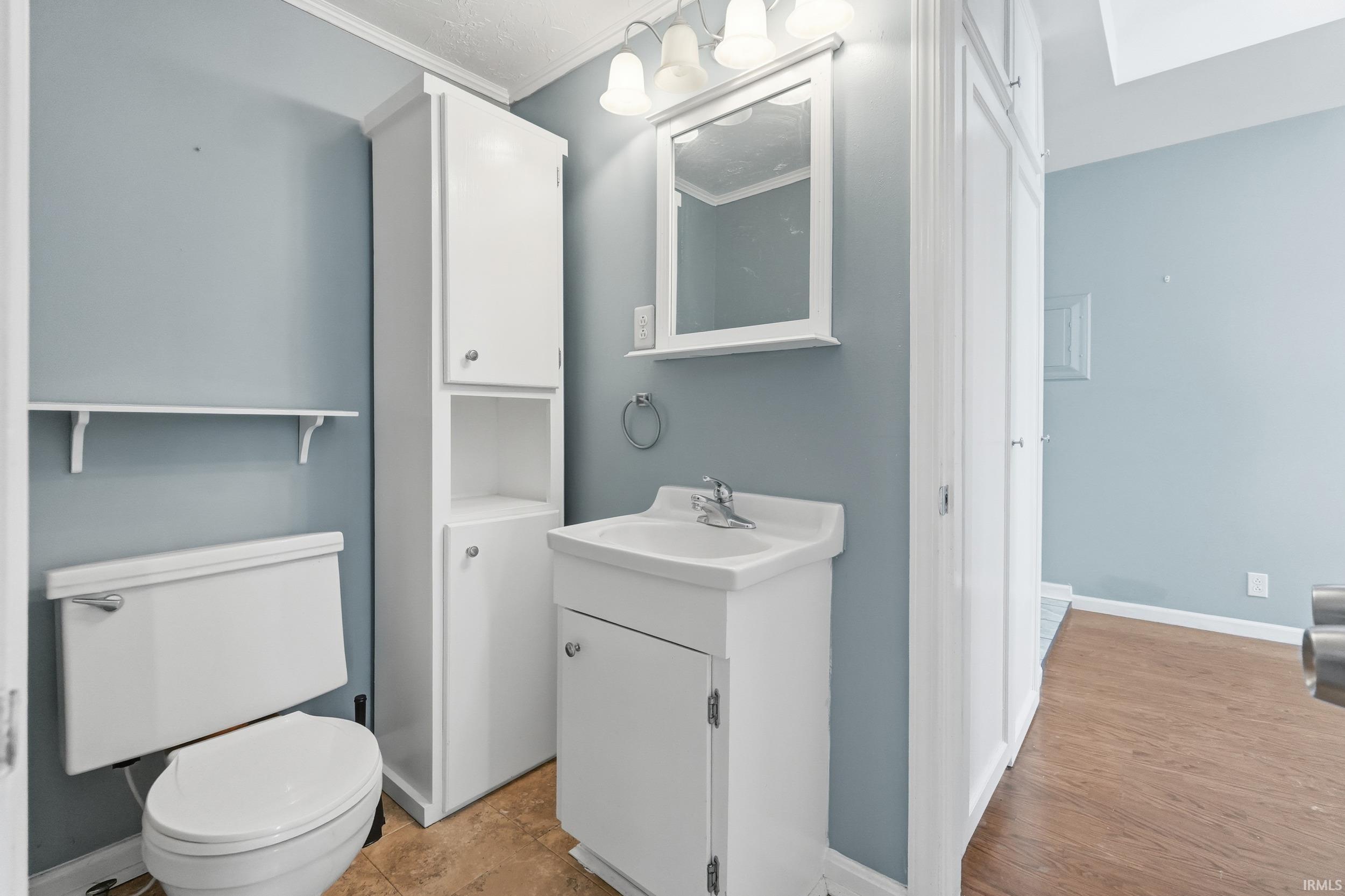 Bathroom with vanity and ornamental molding