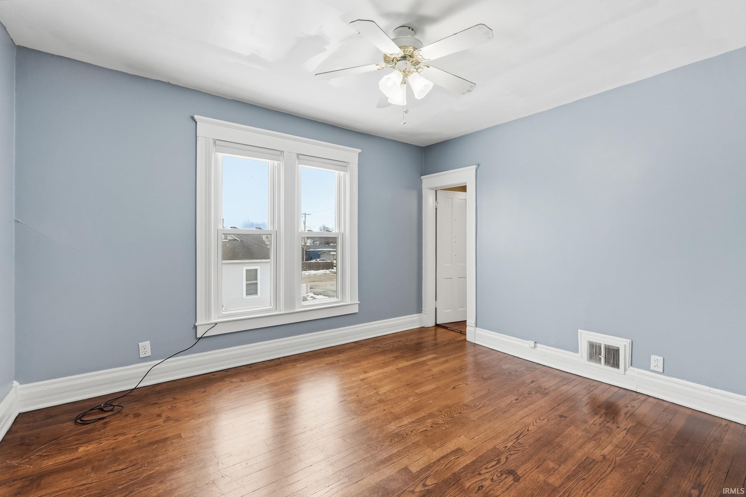 Unfurnished room featuring hardwood / wood-style floors and a ceiling fan