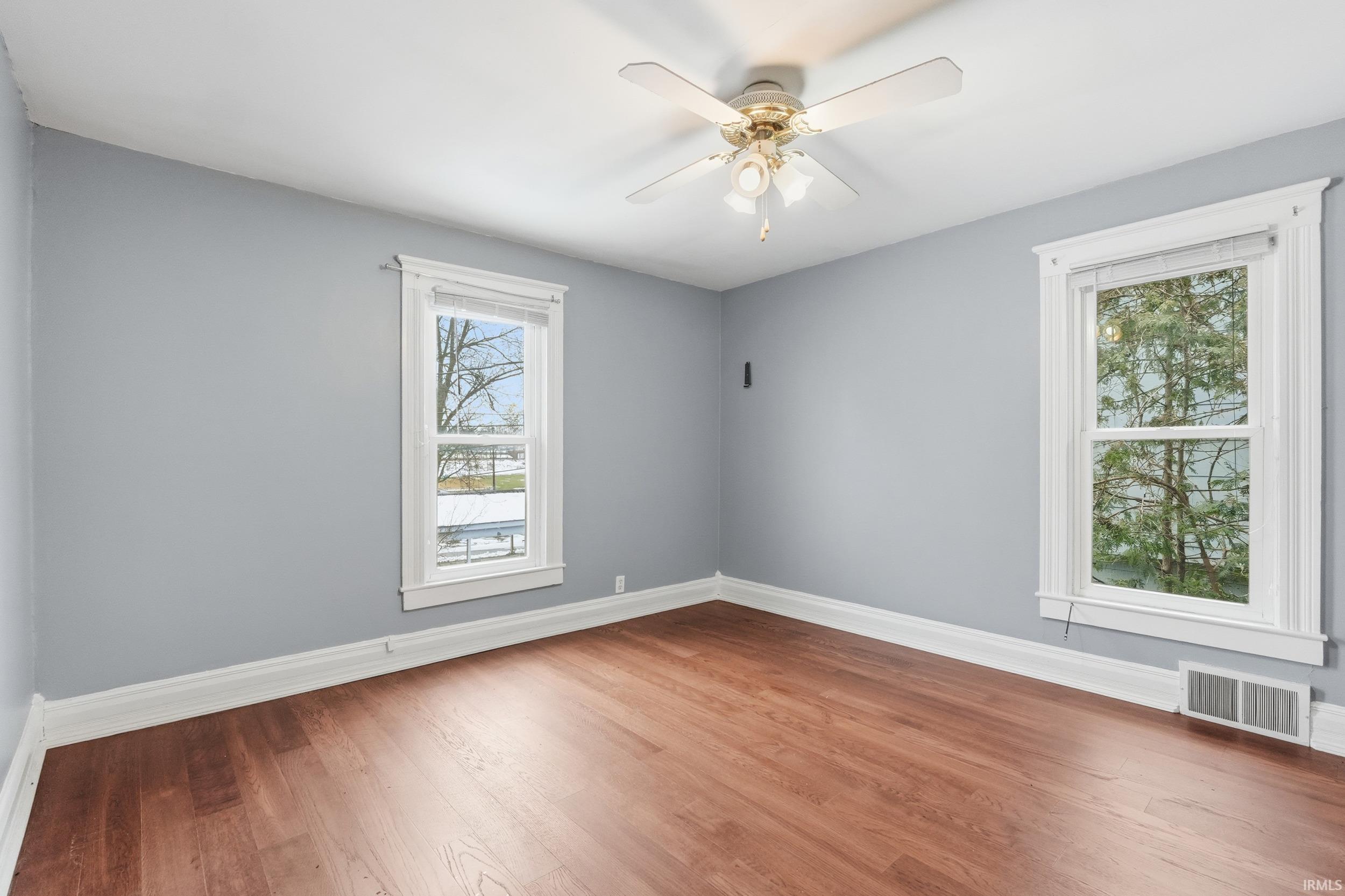 Spare room featuring wood finished floors and a ceiling fan