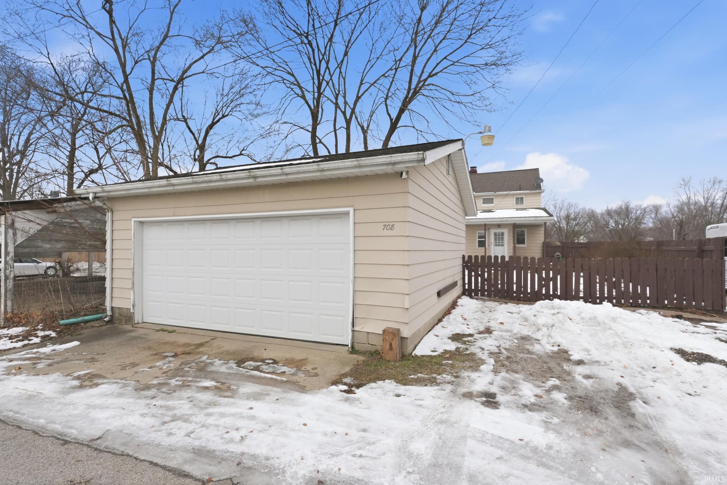 Snow covered garage with a garage