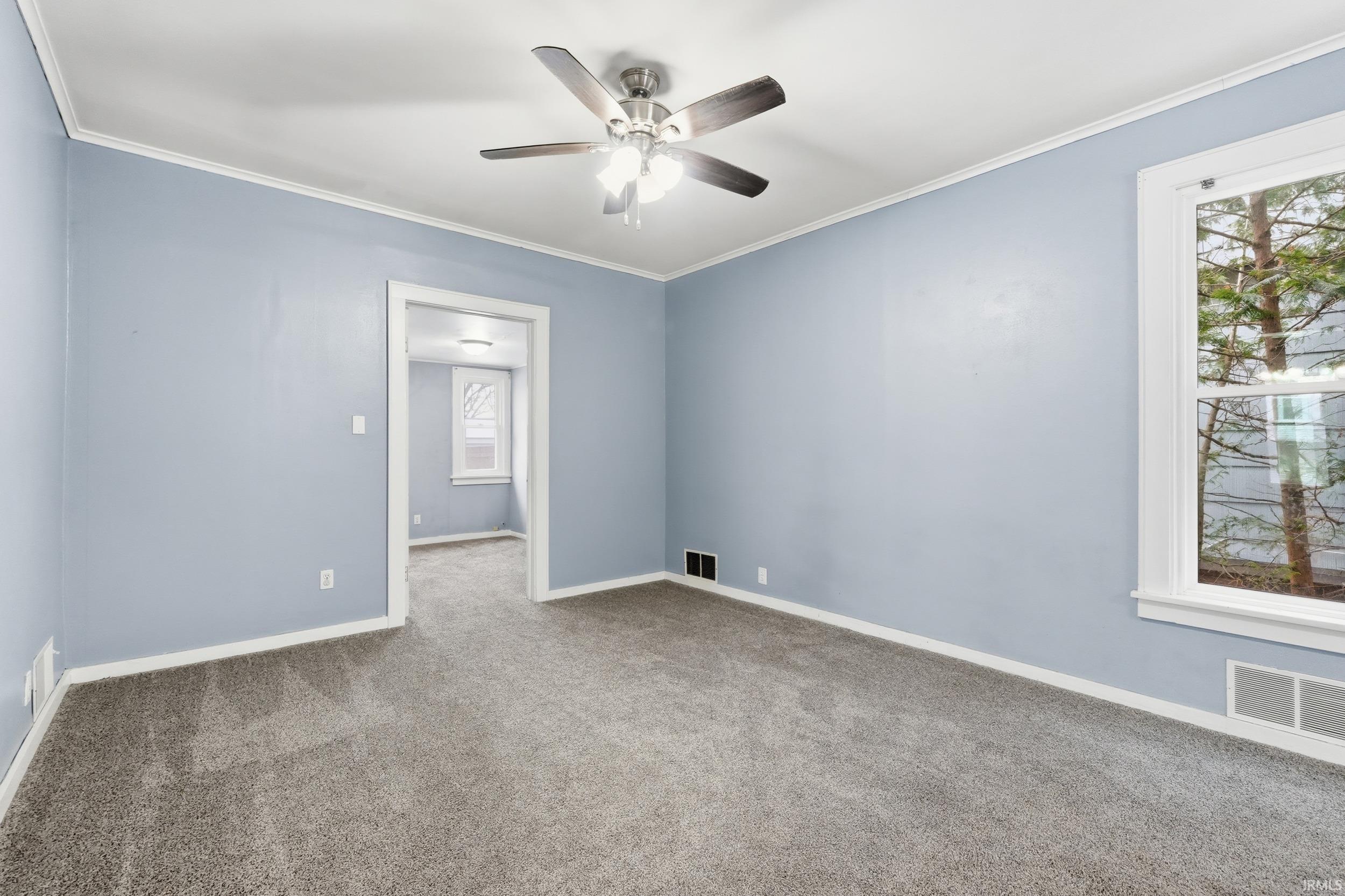 Carpeted empty room with ornamental molding and ceiling fan