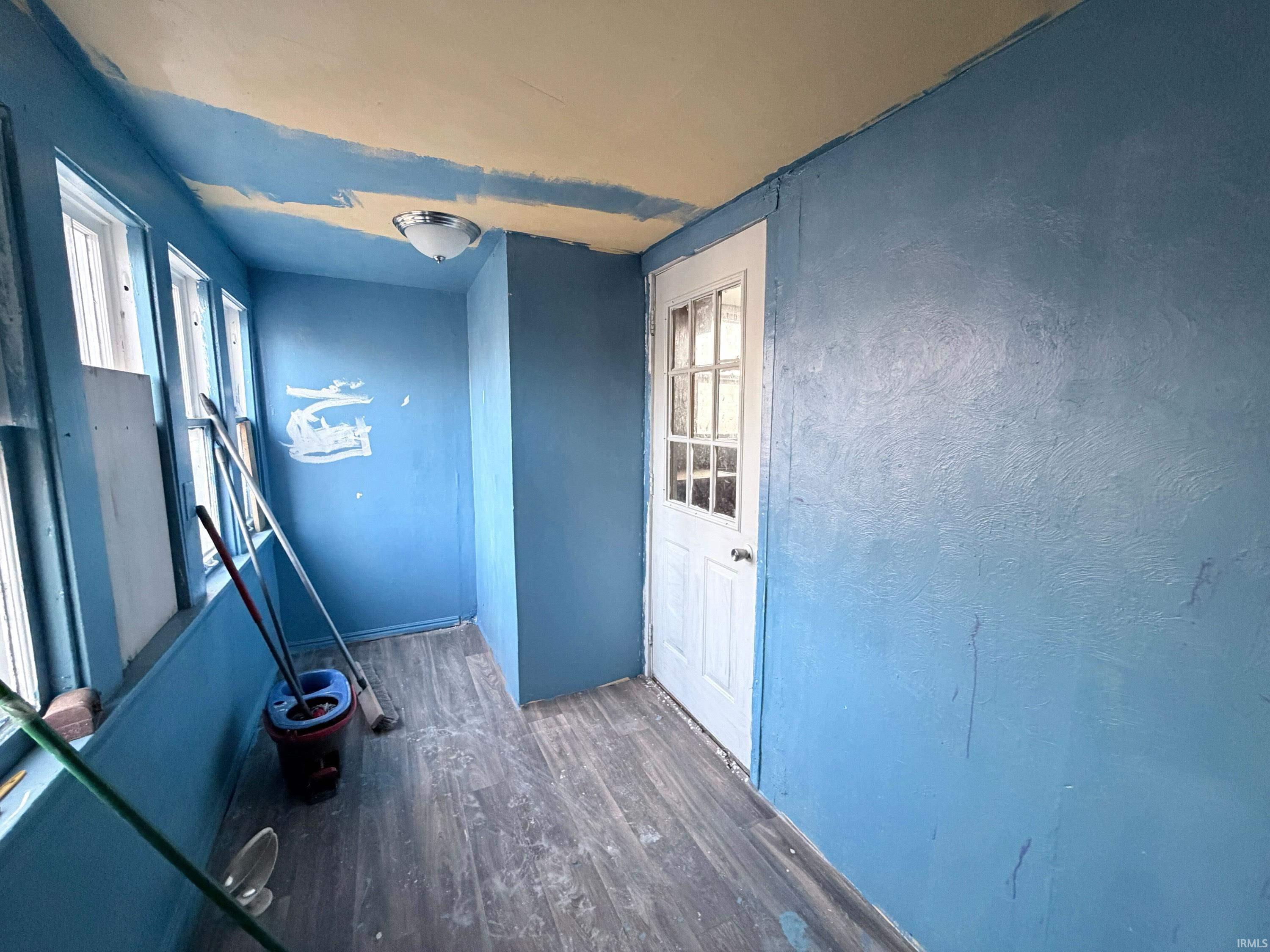 Entryway with wood finished floors, healthy amount of natural light, and a textured wall