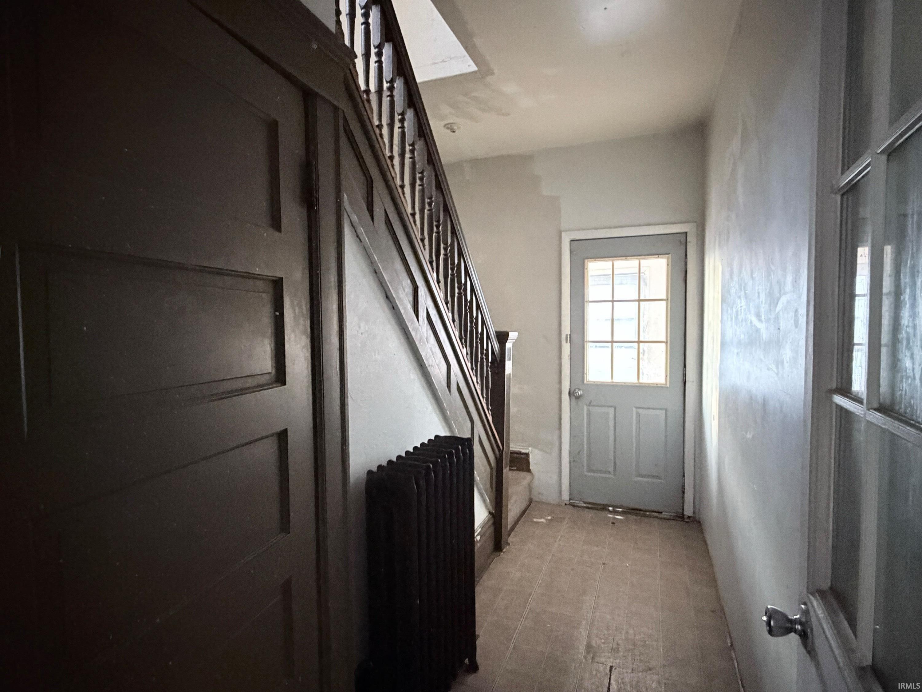 Doorway to outside with stairs and radiator heating unit