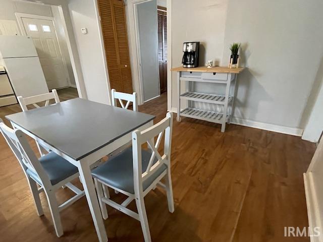 Dining area with dark wood-type flooring