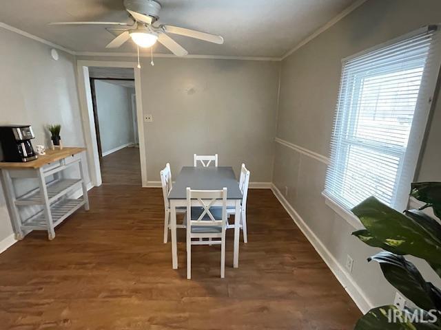 Dining space featuring dark wood-style floors, ornamental molding, and ceiling fan