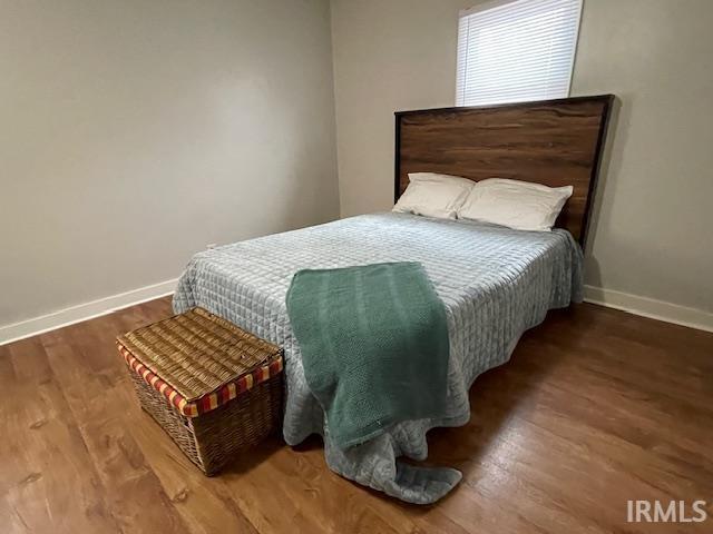 Bedroom with baseboards and wood finished floors