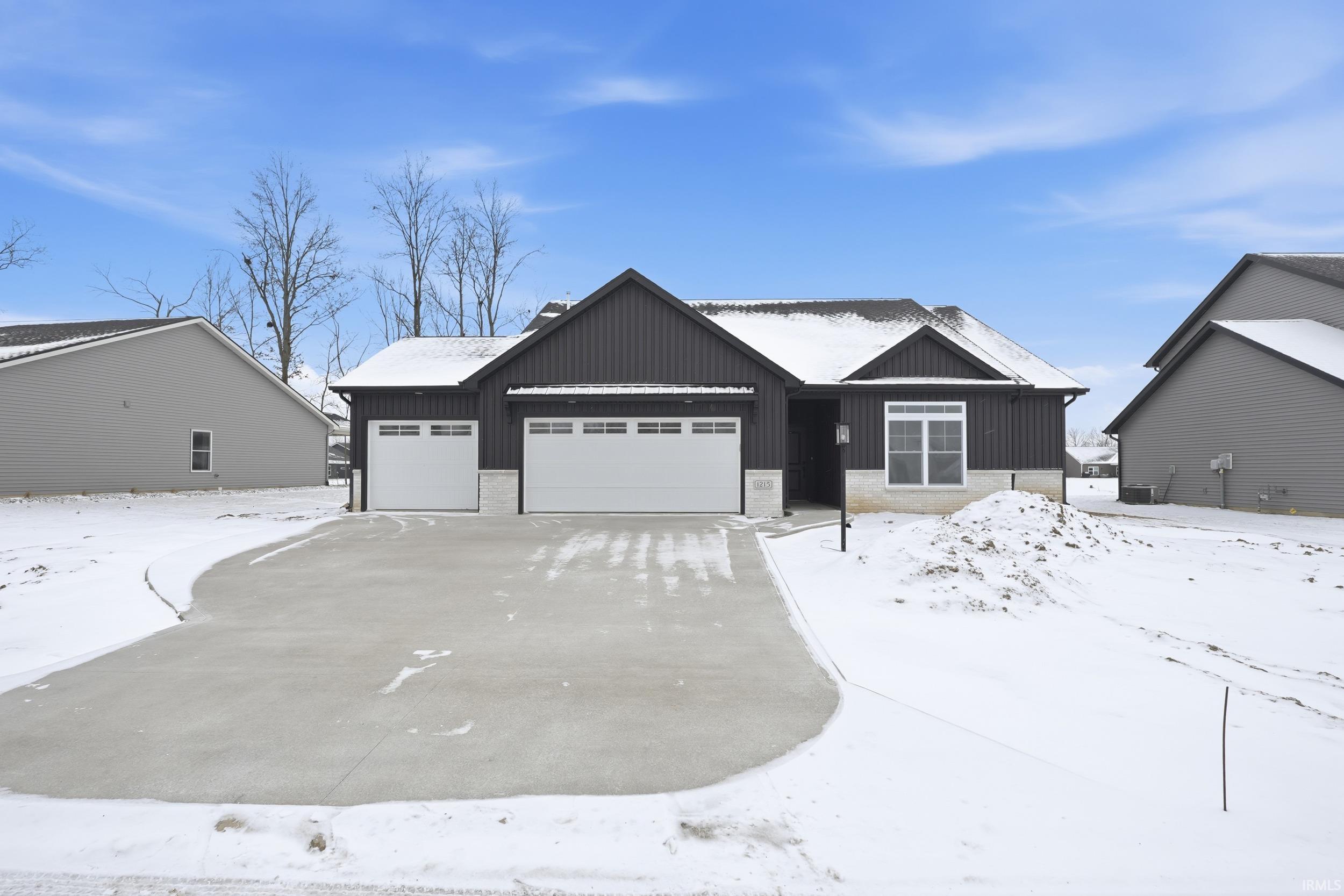 View of front of home featuring board and batten siding, a garage, and driveway