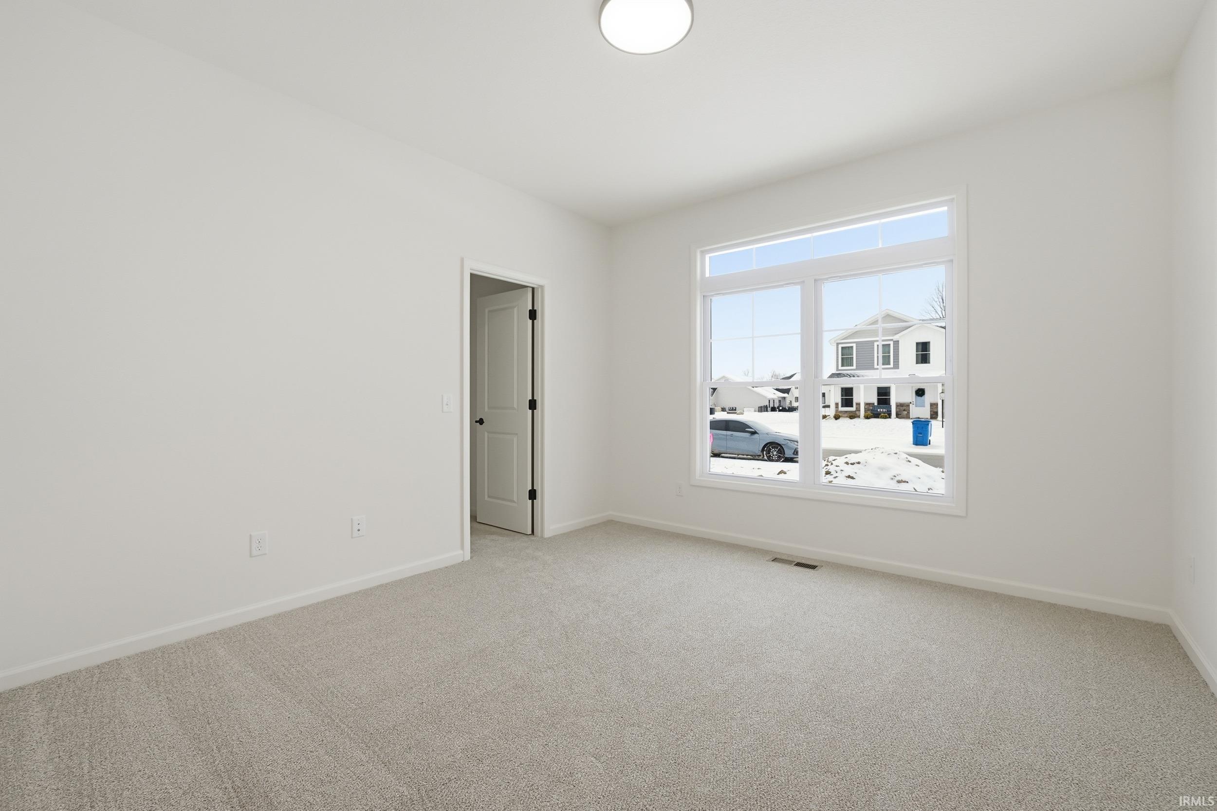 Carpeted spare room with baseboards