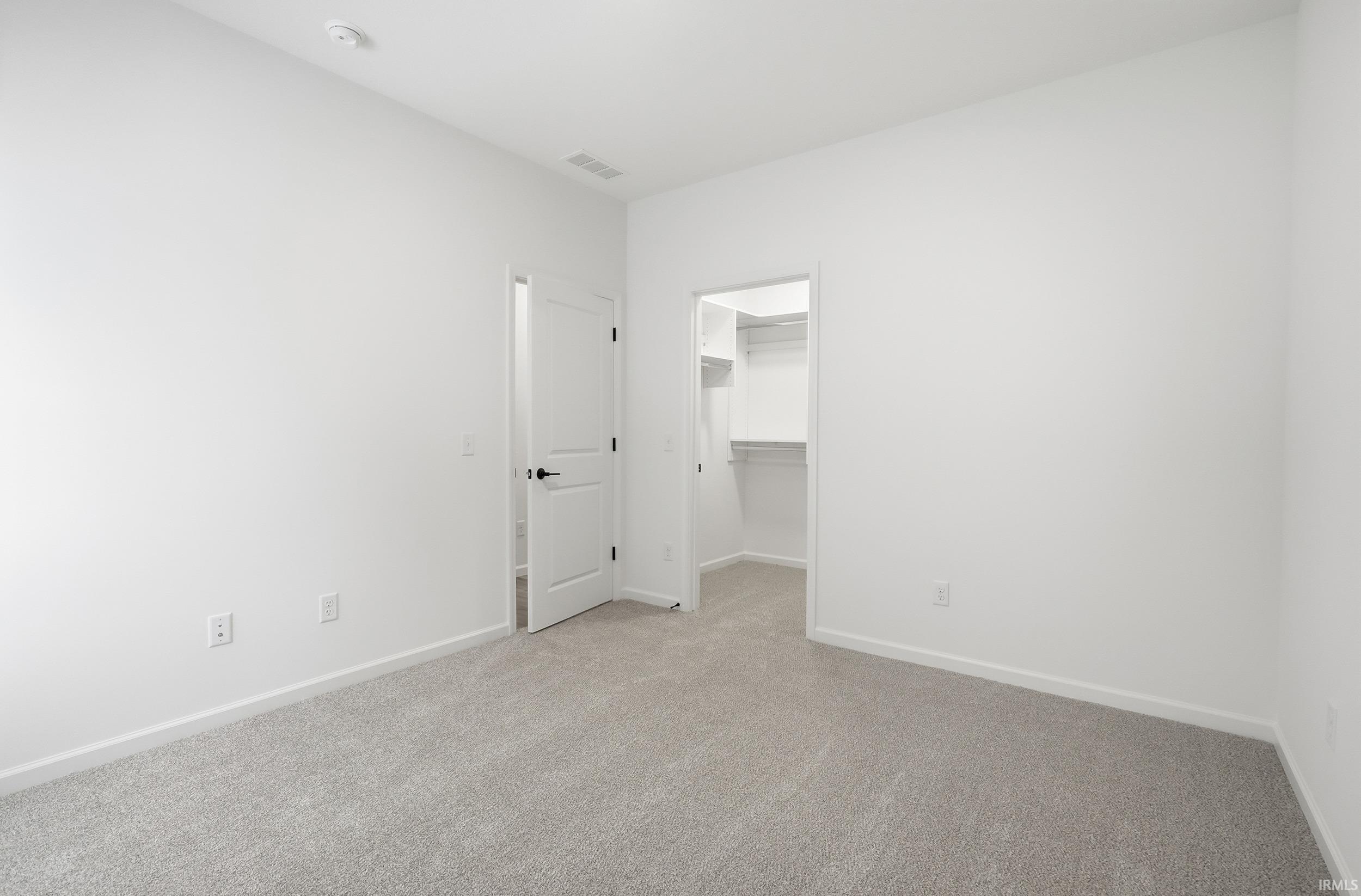 Unfurnished bedroom with a spacious closet and carpet floors