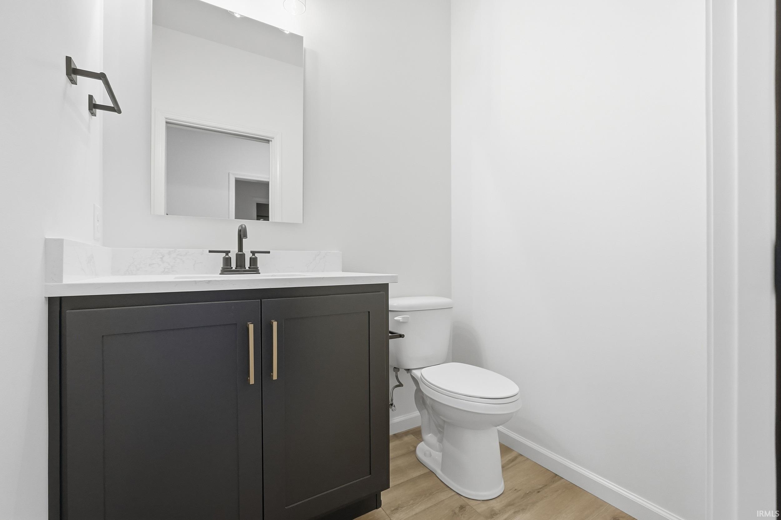 Half bathroom featuring vanity and light wood-style flooring