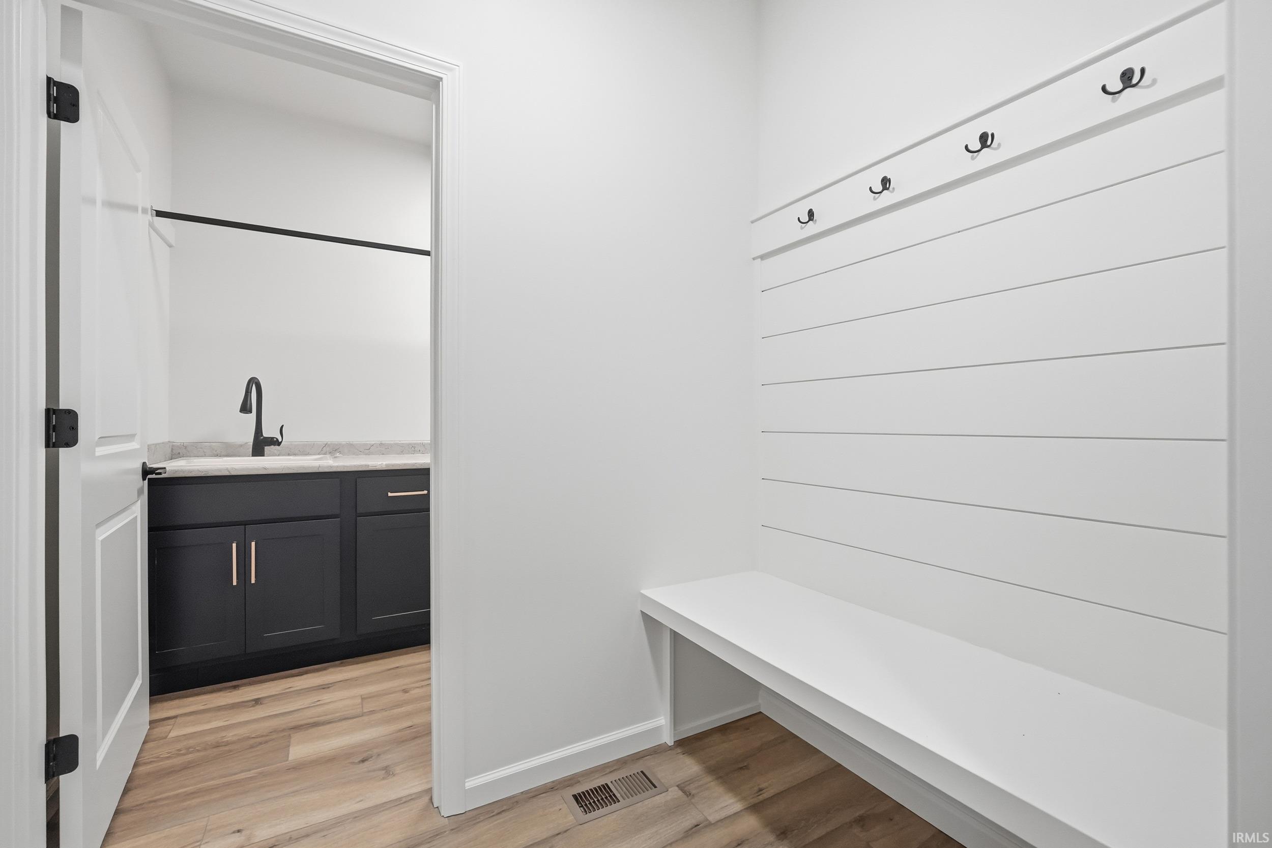 Mudroom featuring light wood-style flooring and a sink