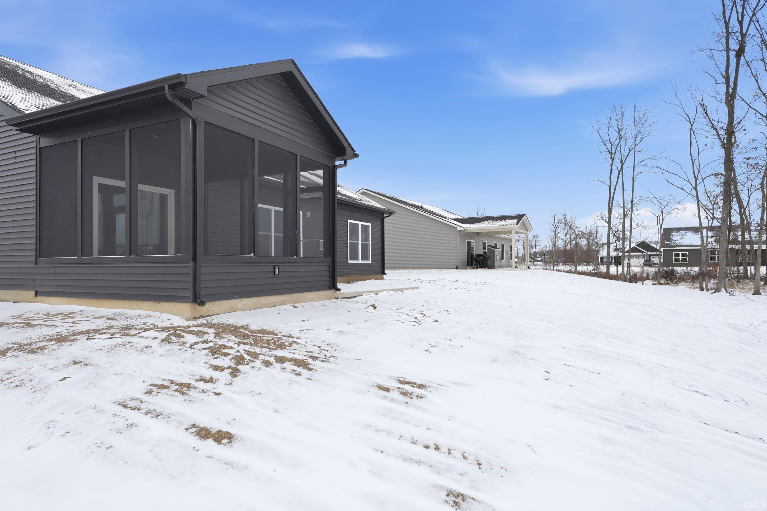 View of snow covered exterior with a sunroom