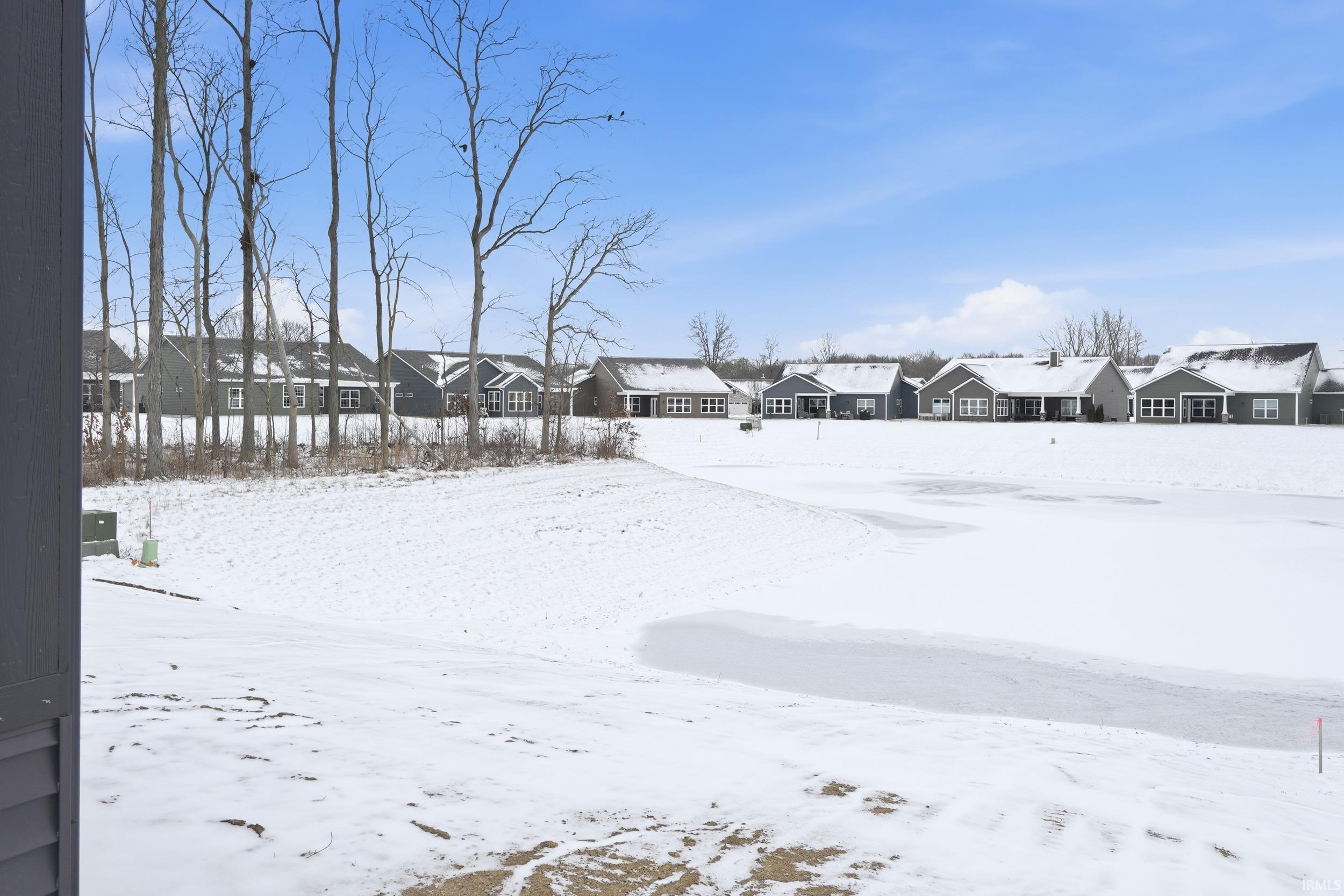 Snowy yard featuring a residential view